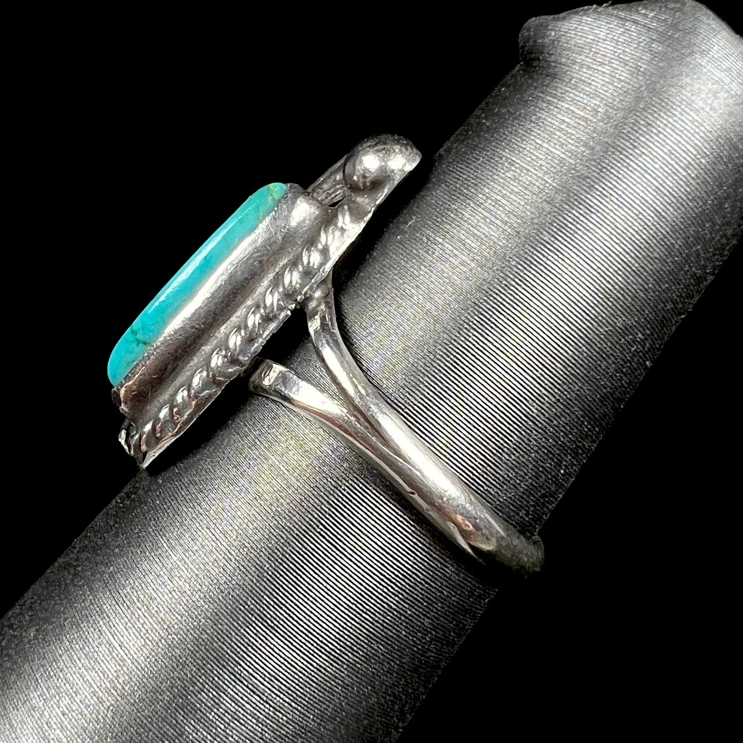 A ladies' sterling silver feather style ring set with a marquise cut turquoise stone.