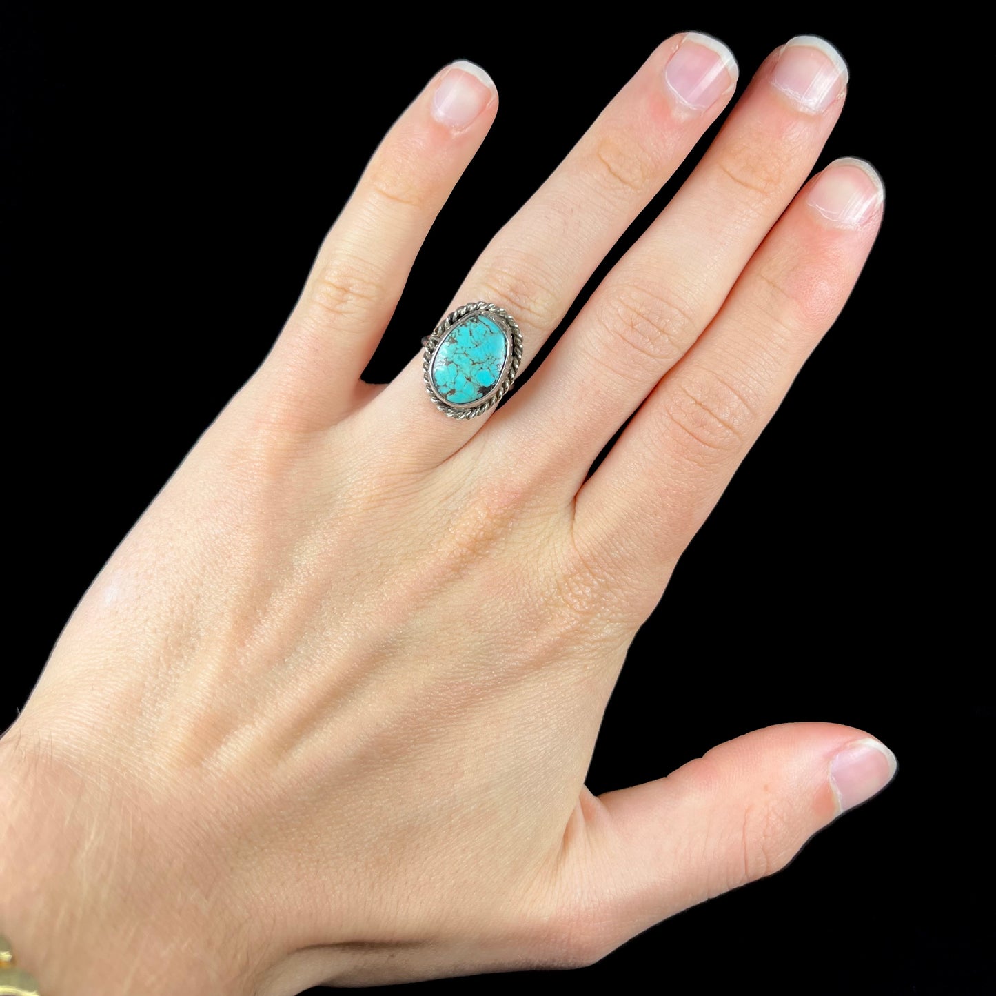 A handmade ladies' turquoise solitaire ring. The ring has a rope bezel design.