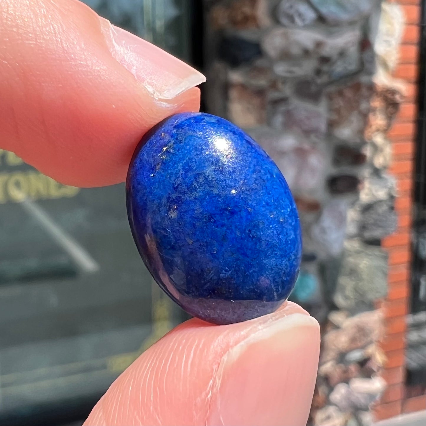 A loose, oval cabochon cut lapis lazuli stone from Blue Mountain, Afghanistan.