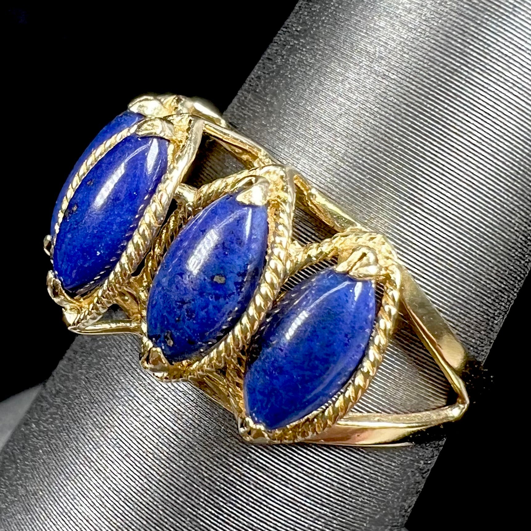 A ladies' five stone marquise cabochon cut lapis lazuli ring in yellow gold.
