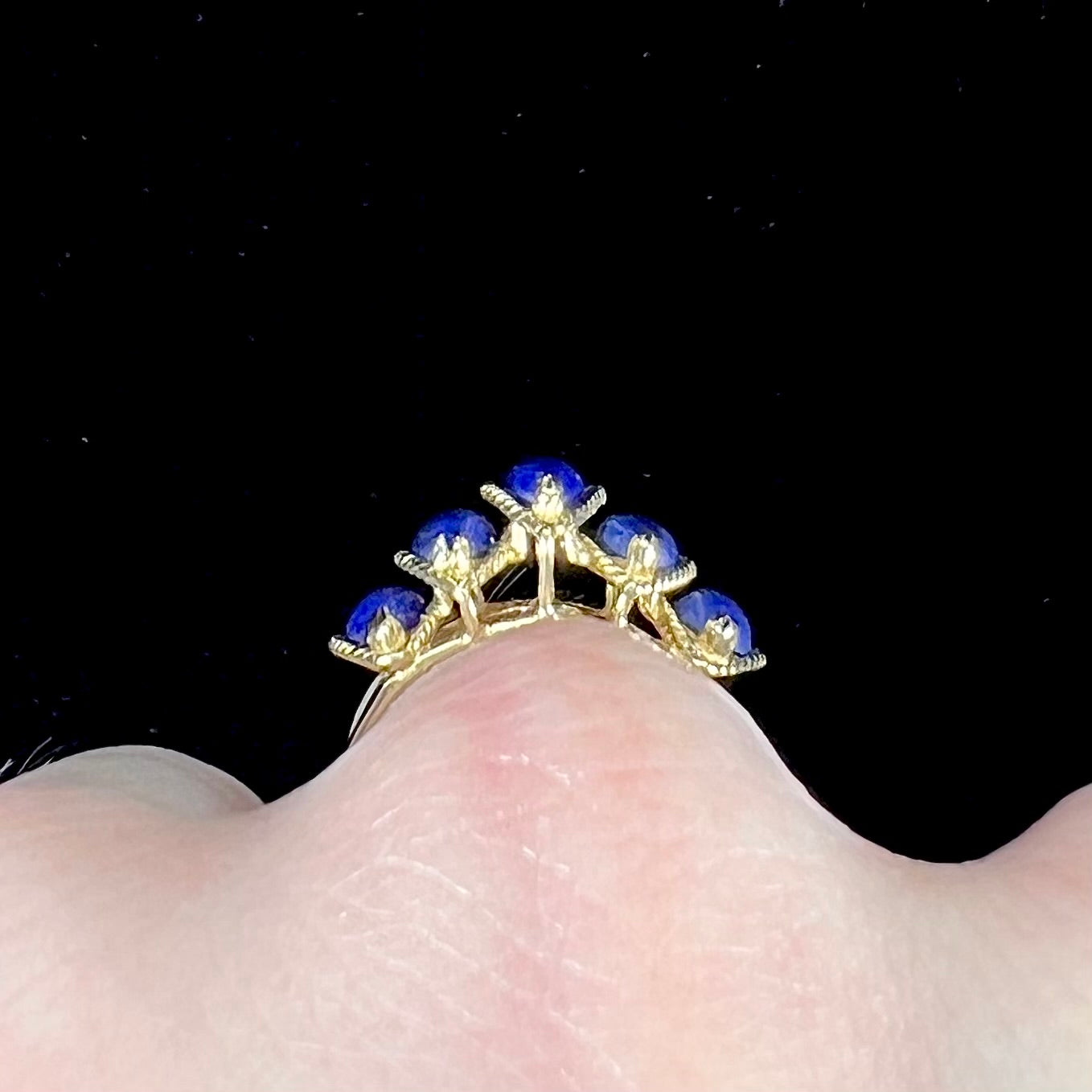 A ladies' five stone marquise cabochon cut lapis lazuli ring in yellow gold.