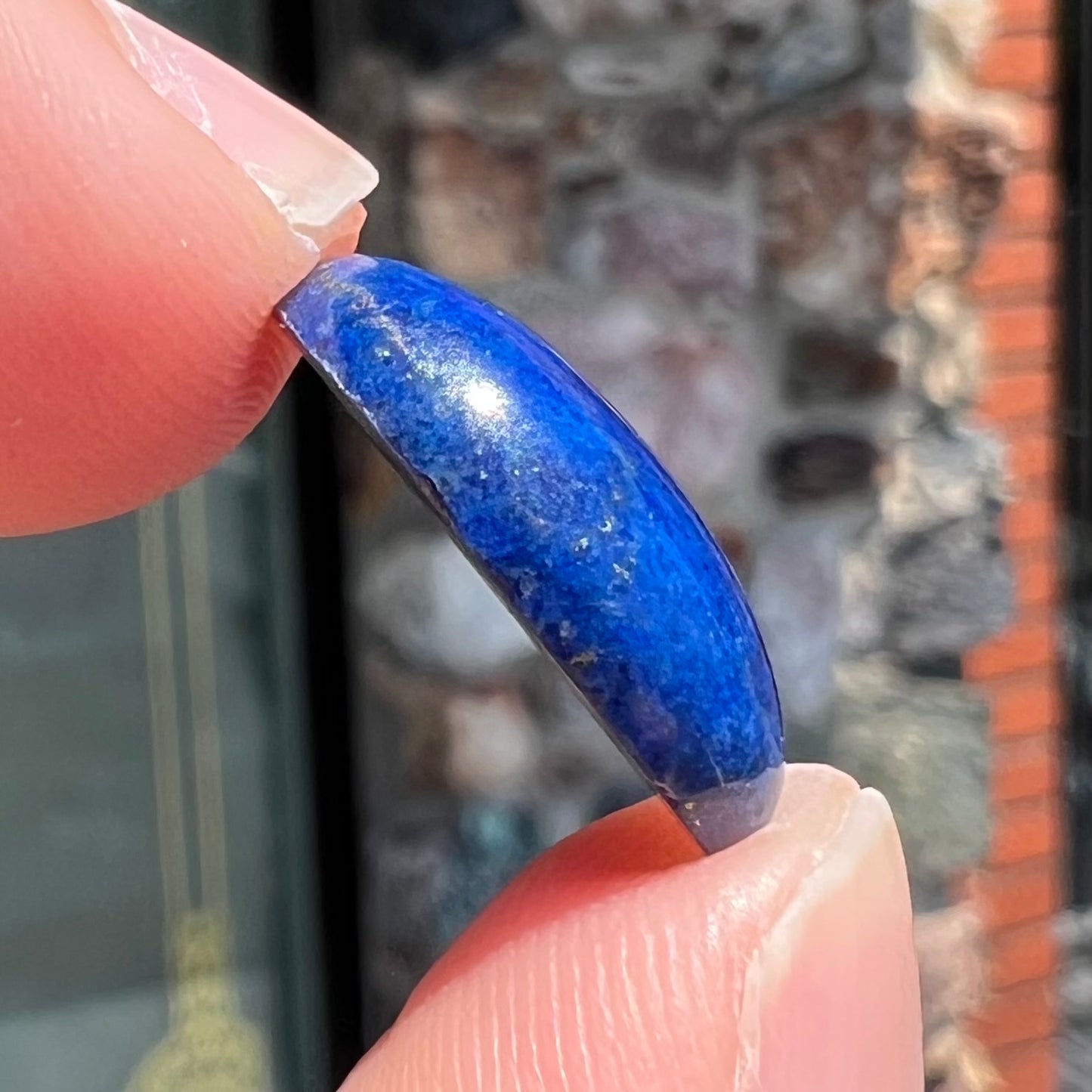 A loose, oval cabochon cut lapis lazuli stone from Blue Mountain, Afghanistan.
