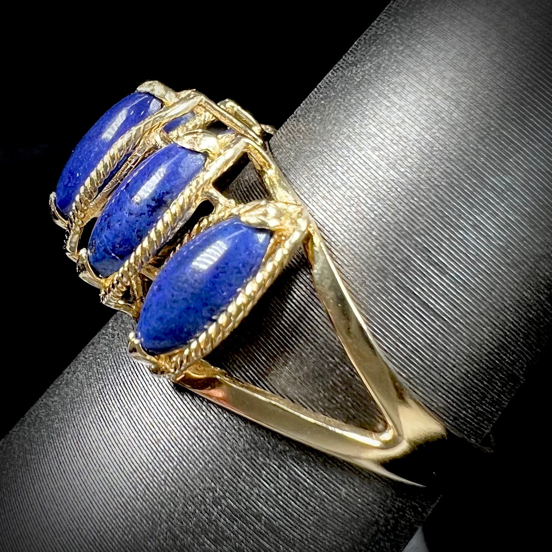 A ladies' five stone marquise cabochon cut lapis lazuli ring in yellow gold.