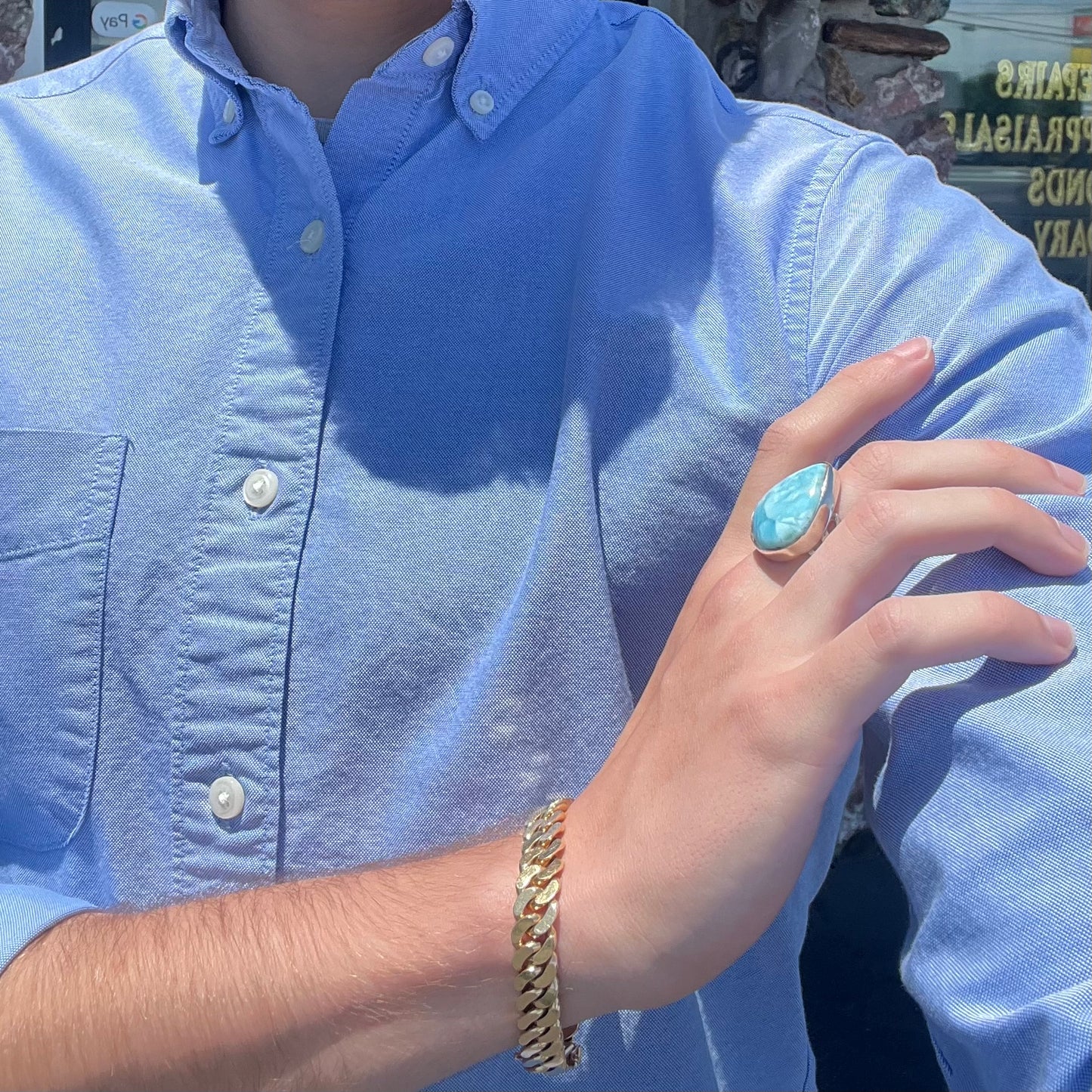 A ladies' large, pear shaped larimar solitaire ring in sterling silver. The larimar stone measures an inch long.