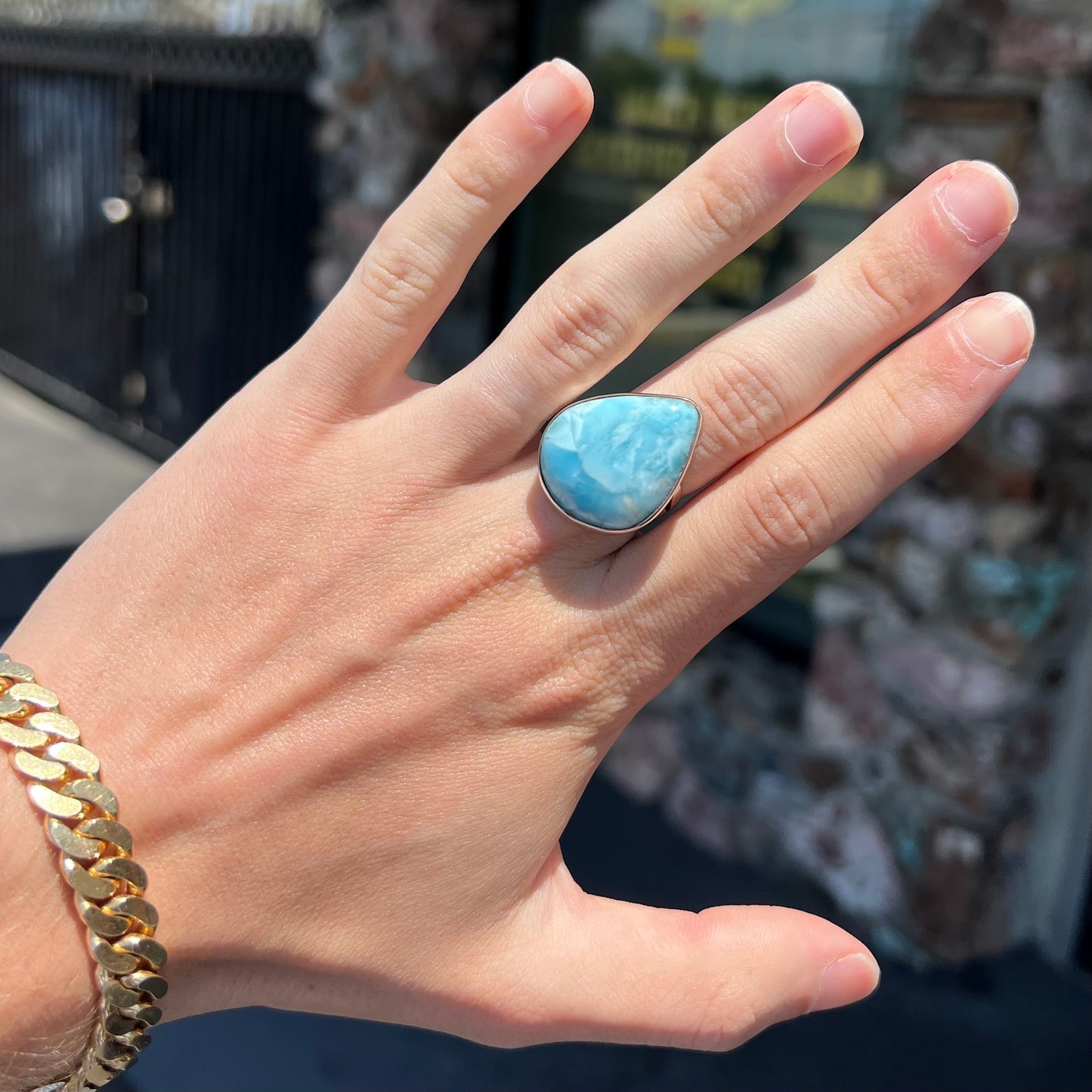 A ladies' large, pear shaped larimar solitaire ring in sterling silver. The larimar stone measures an inch long.