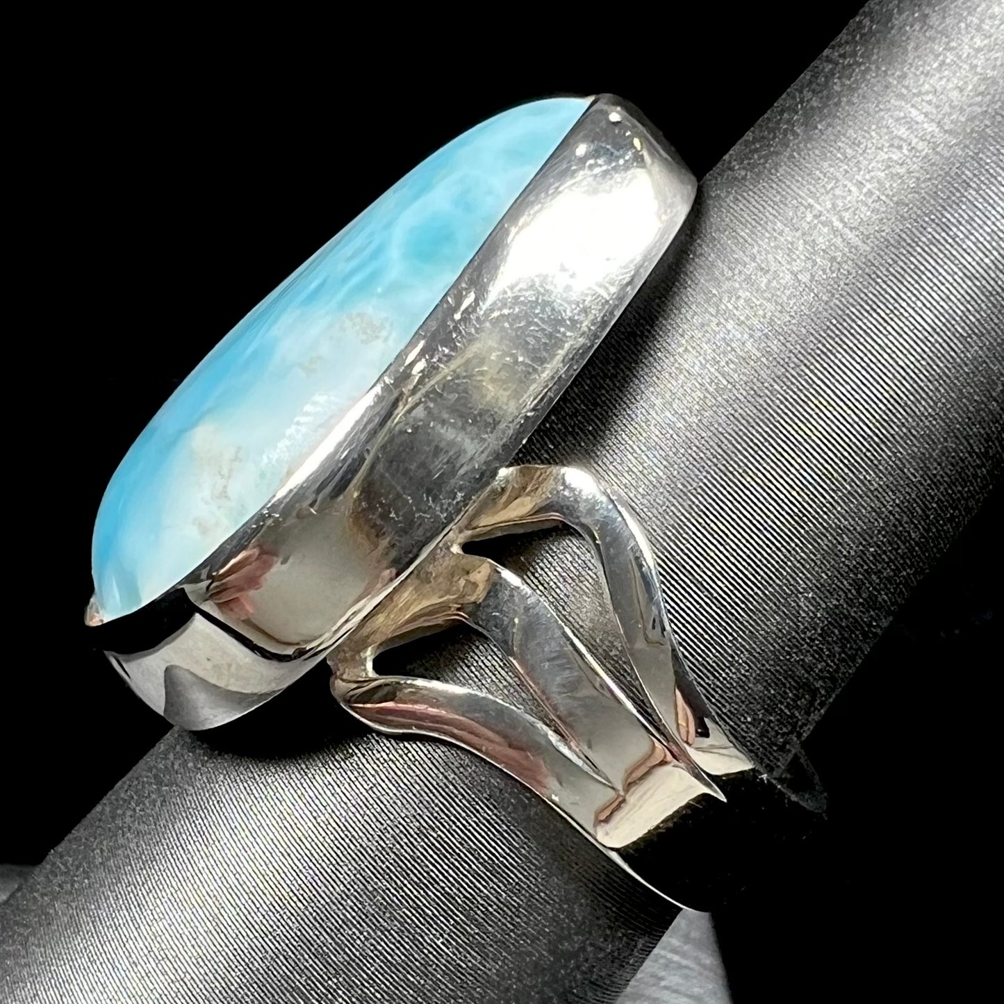 A ladies' large, pear shaped larimar solitaire ring in sterling silver. The larimar stone measures an inch long.