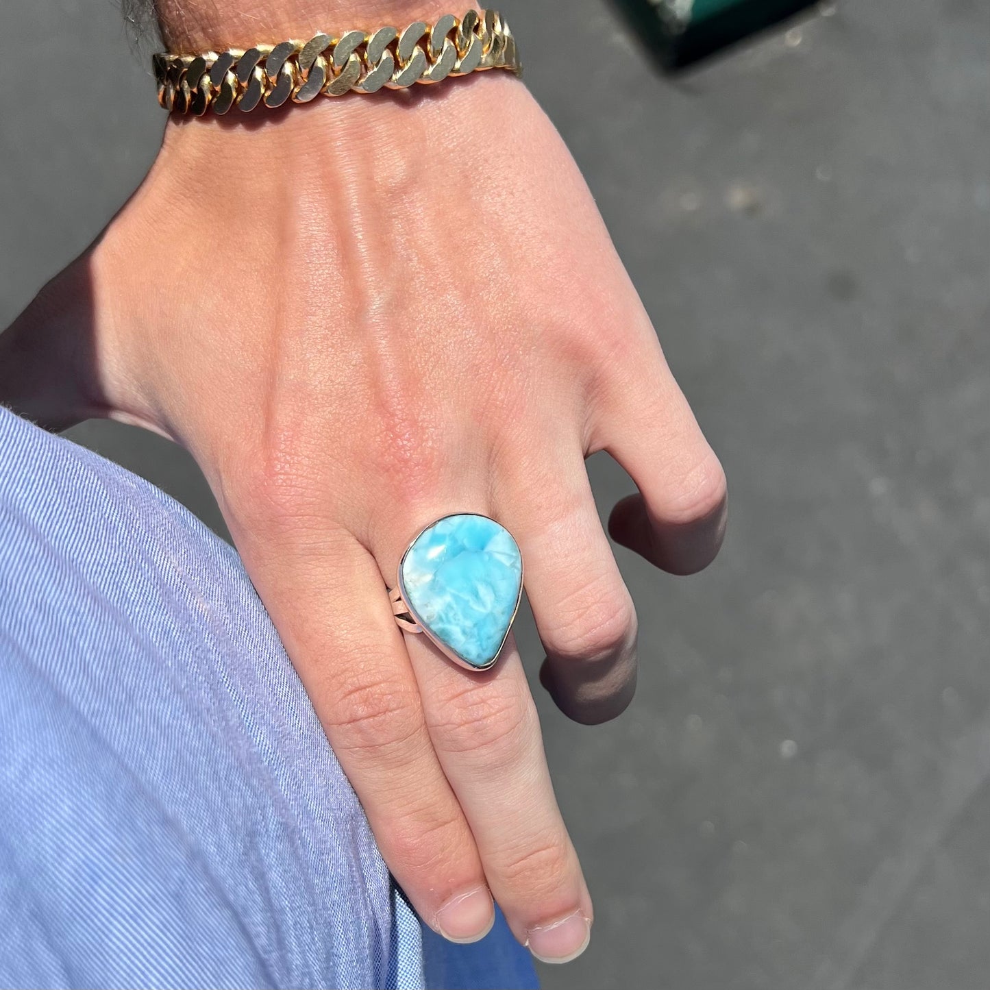 A ladies' large, pear shaped larimar solitaire ring in sterling silver. The larimar stone measures an inch long.