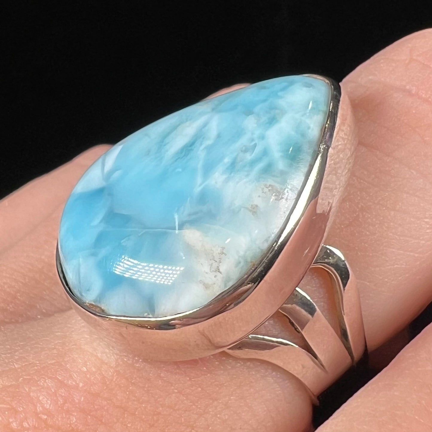 A ladies' large, pear shaped larimar solitaire ring in sterling silver. The larimar stone measures an inch long.