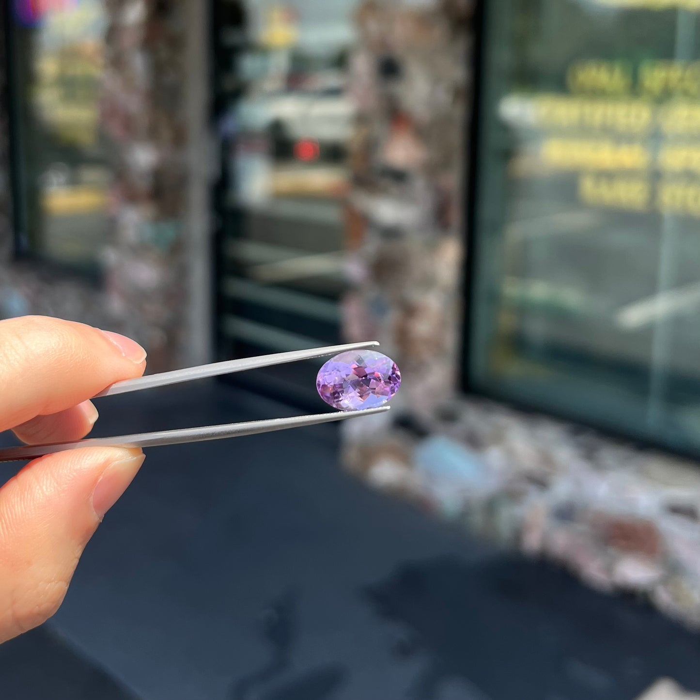 A faceted oval cut amethyst gemstone. The stone is a light purple color.
