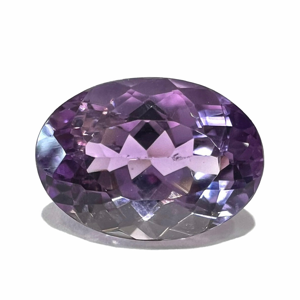 A faceted oval cut amethyst gemstone. The stone is a light purple color.