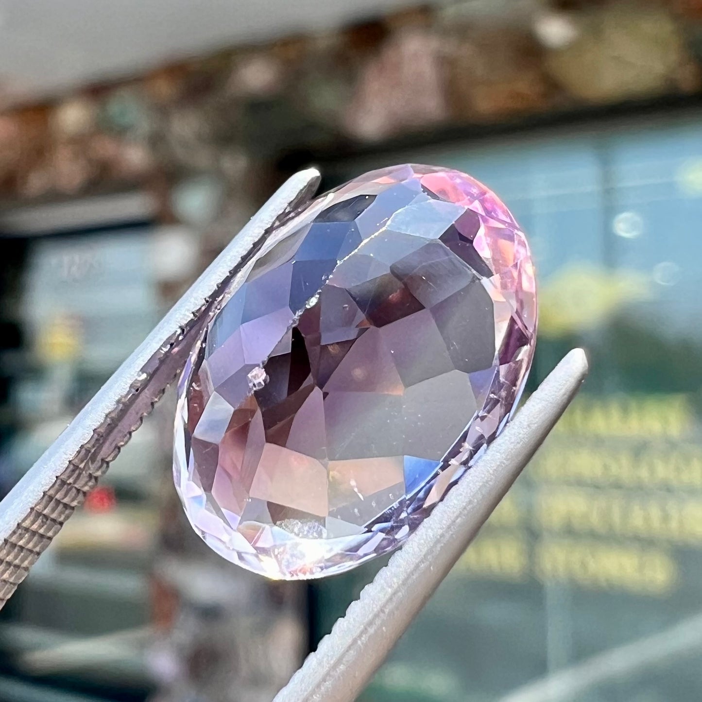 A faceted oval cut amethyst gemstone. The stone is a light purple color.