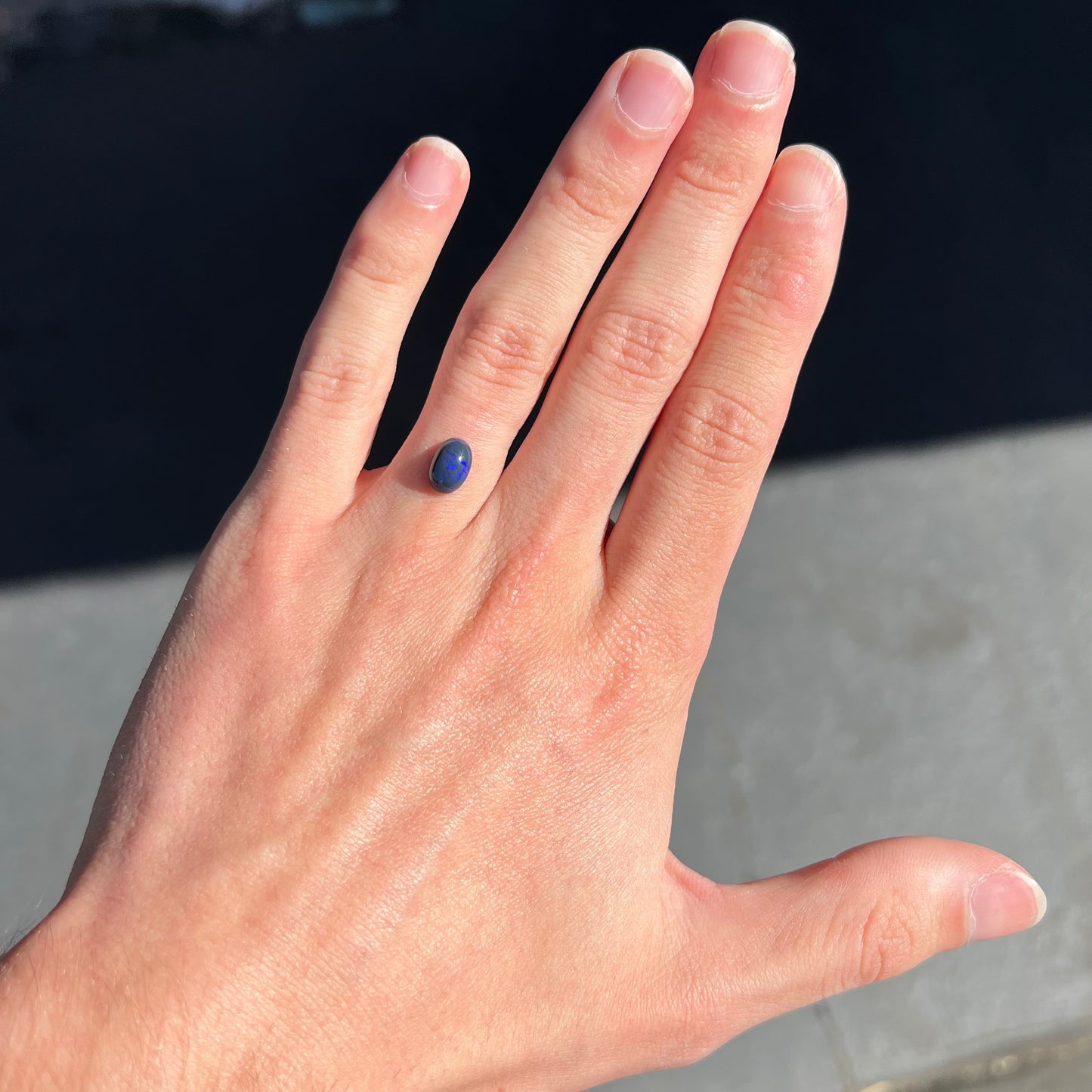 A loose, oval cabochon cut black opal stone from Lightning Ridge, Australia. The opal has an N2 body tone.