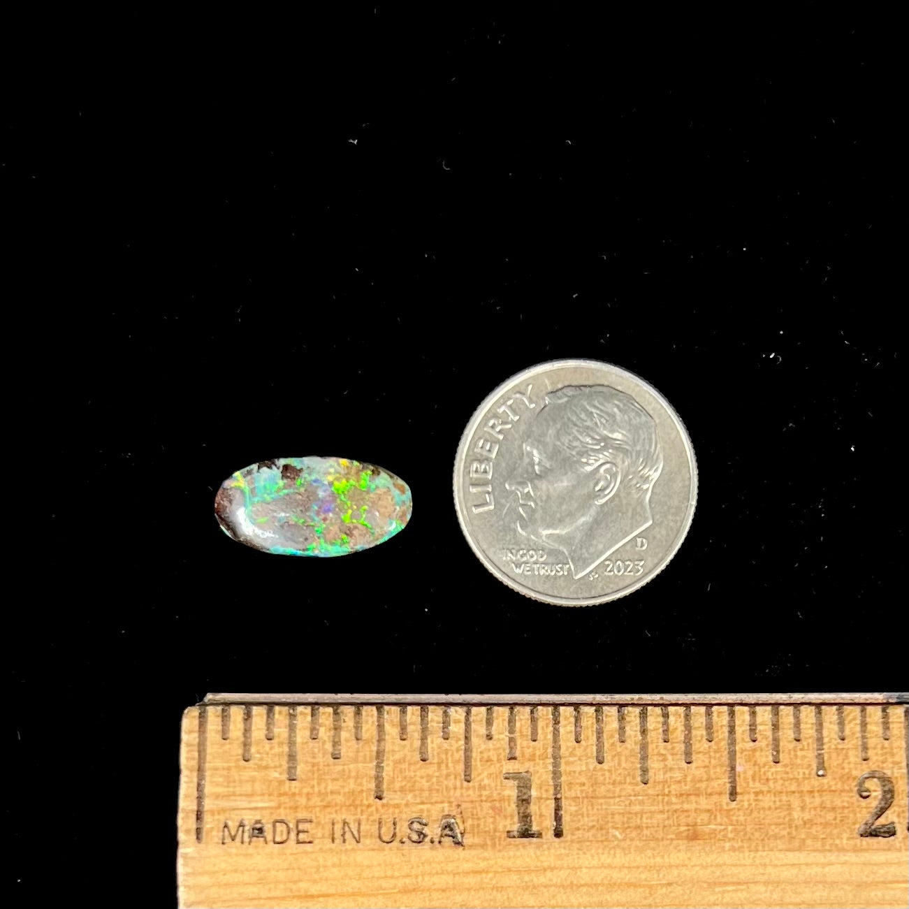 A loose, oval cabochon cut Koroit boulder opal stone. The opal has a bright green color.