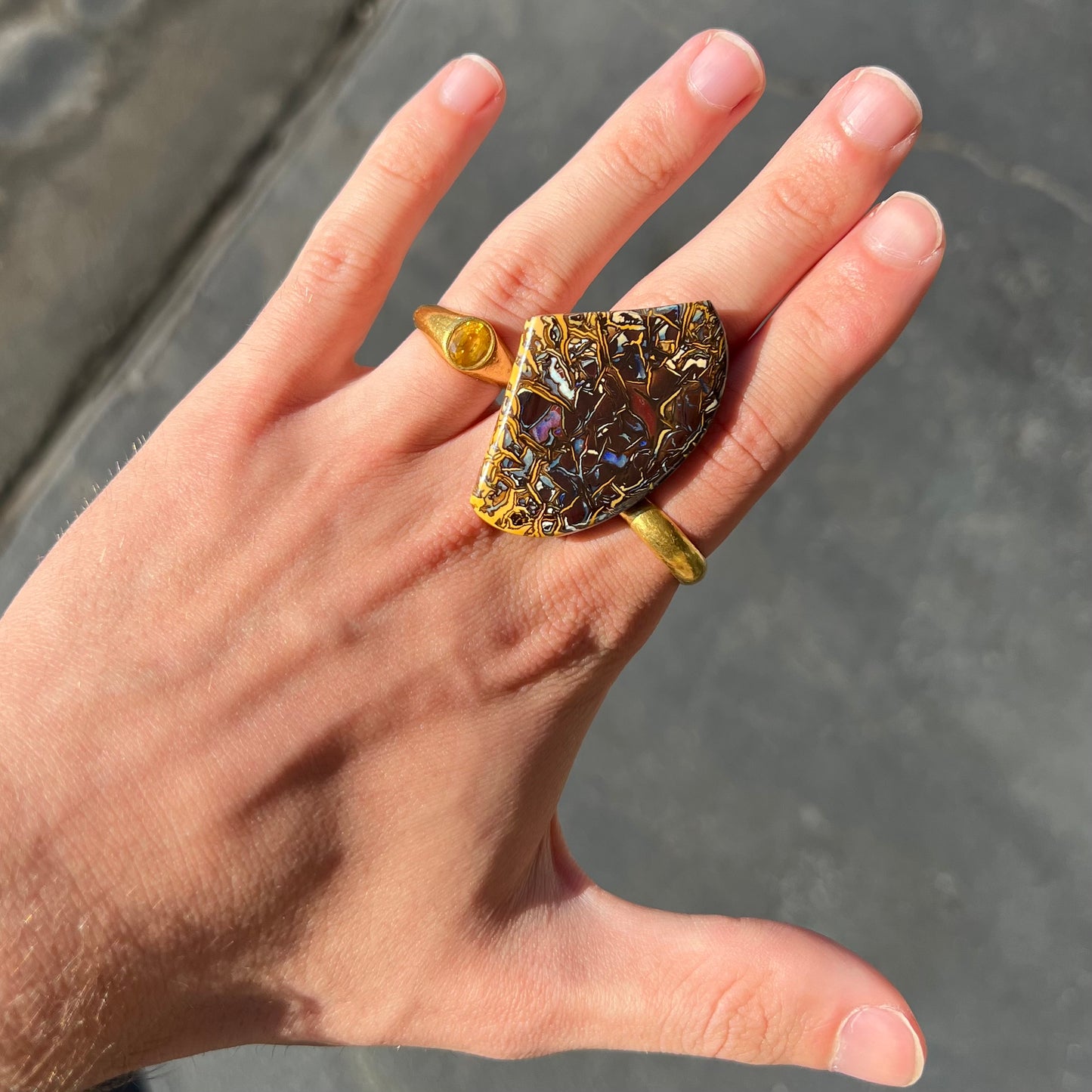 A loose, polished Koroit boulder opal specimen. The opal has an organic pattern.