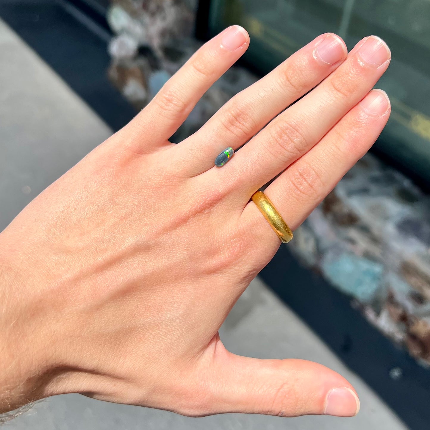 A loose black opal from Lightning Ridge, Australia.  The opal shines colors of red, green, and blue.