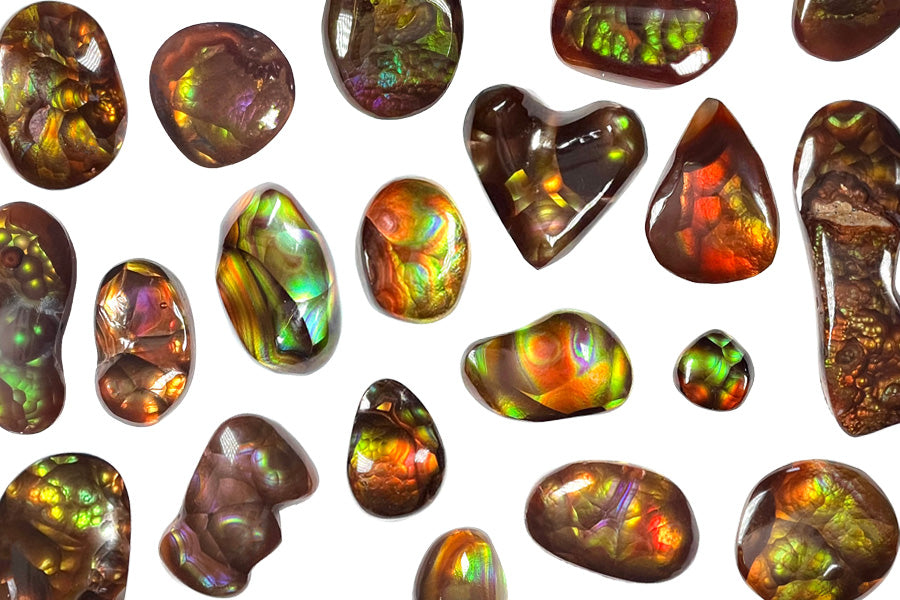 A colorful collection of loose Mexican fire agate stones. Shapes, sizes, patterns, and colors vary.