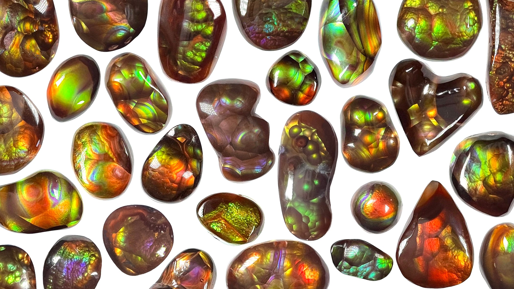 A colorful array of loose Mexican fire agate stones.  All of the stones are different shaped cabochons.