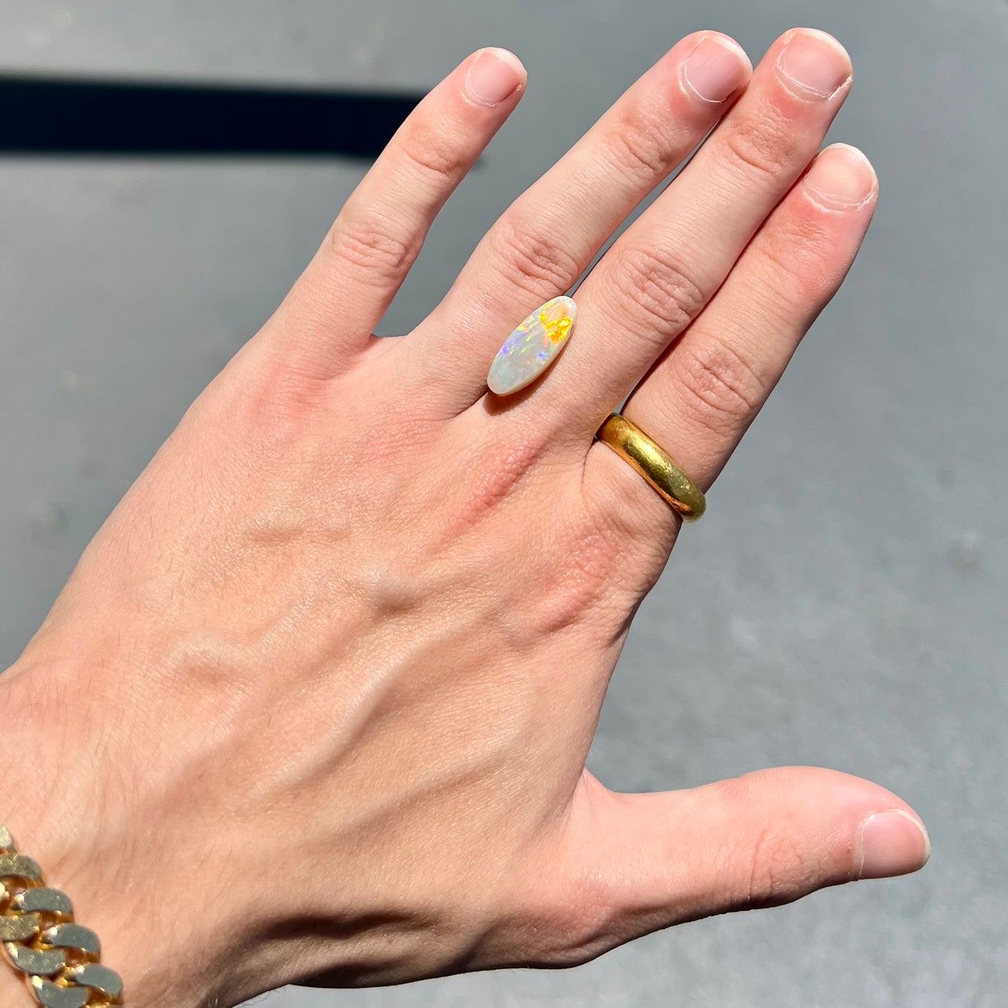 A loose, oval cabochon cut opal stone from Coober Pedy, Australia.