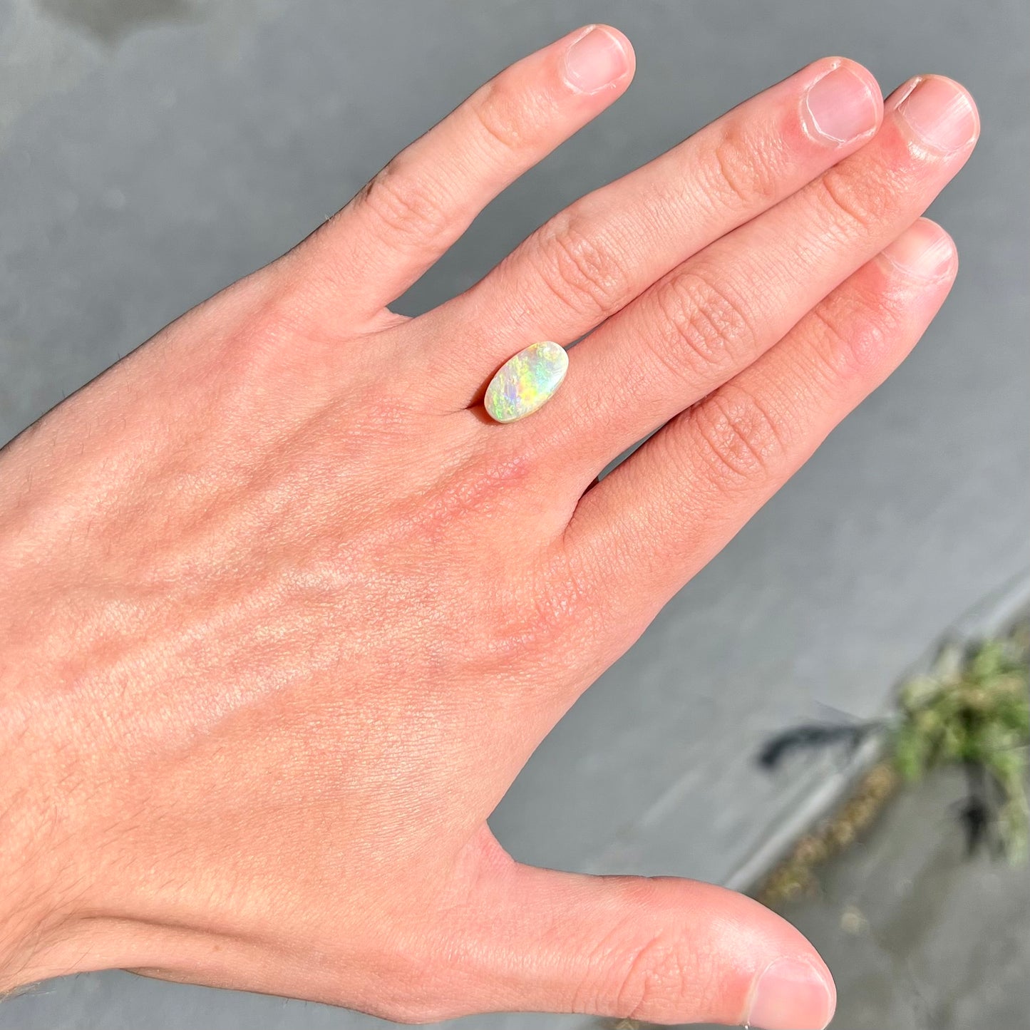 A loose, Lightning Ridge light crystal opal. The opal is predominantly green.