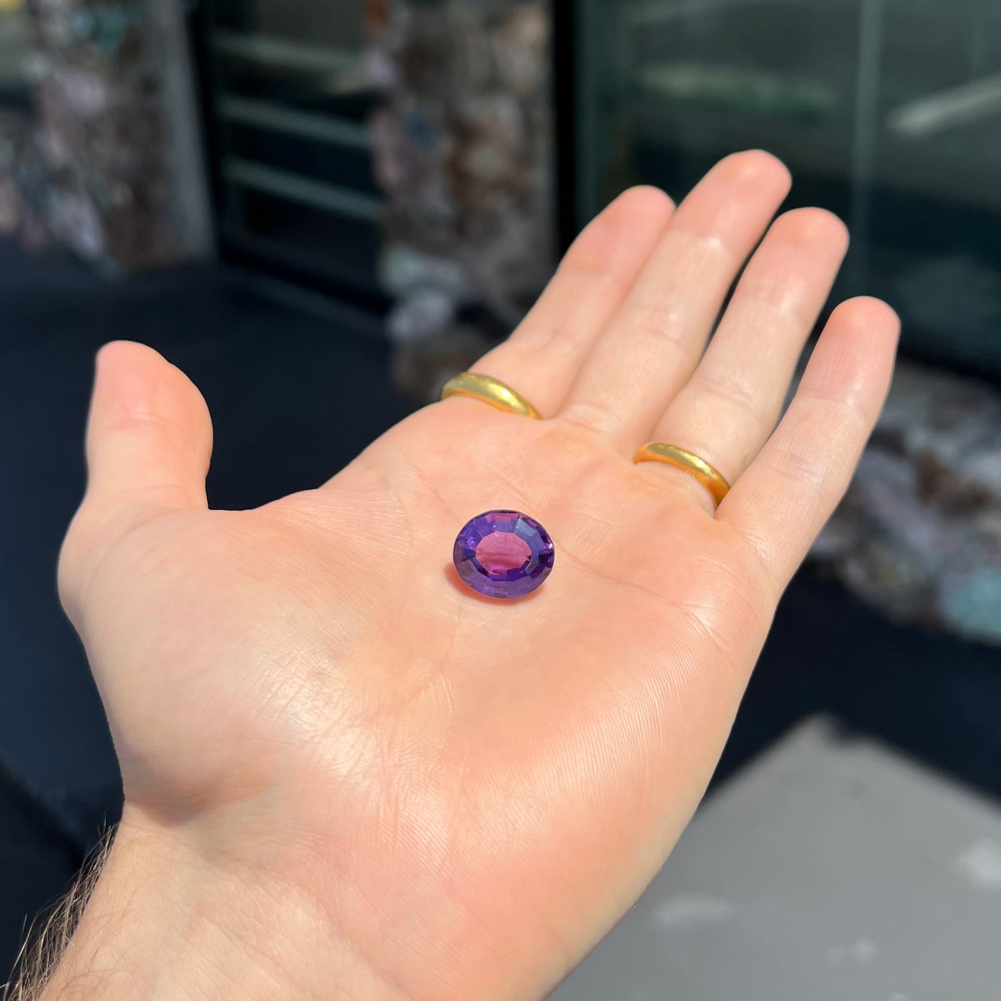 A loose, modified oval cut purple amethyst gemstone.