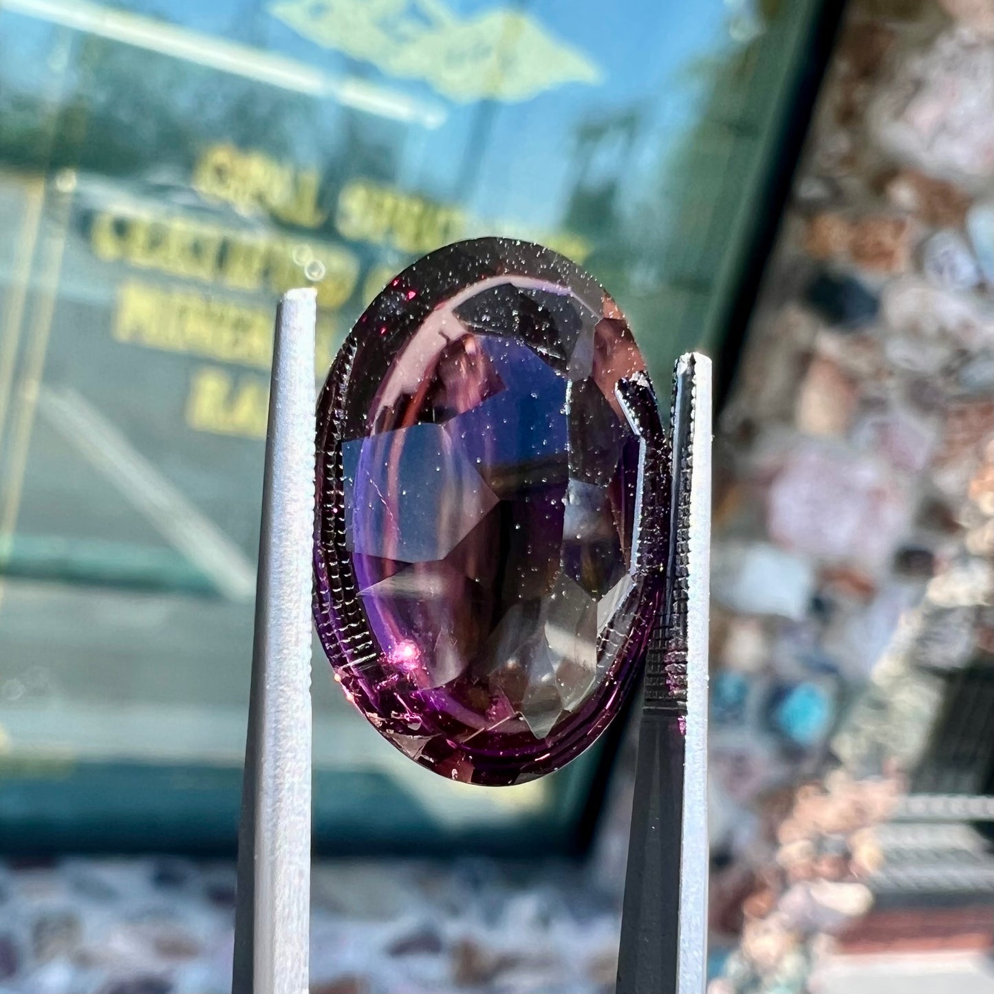 A loose, oval buff top cut amethyst gemstone. The top of the stone is domed, and the bottom is faceted.
