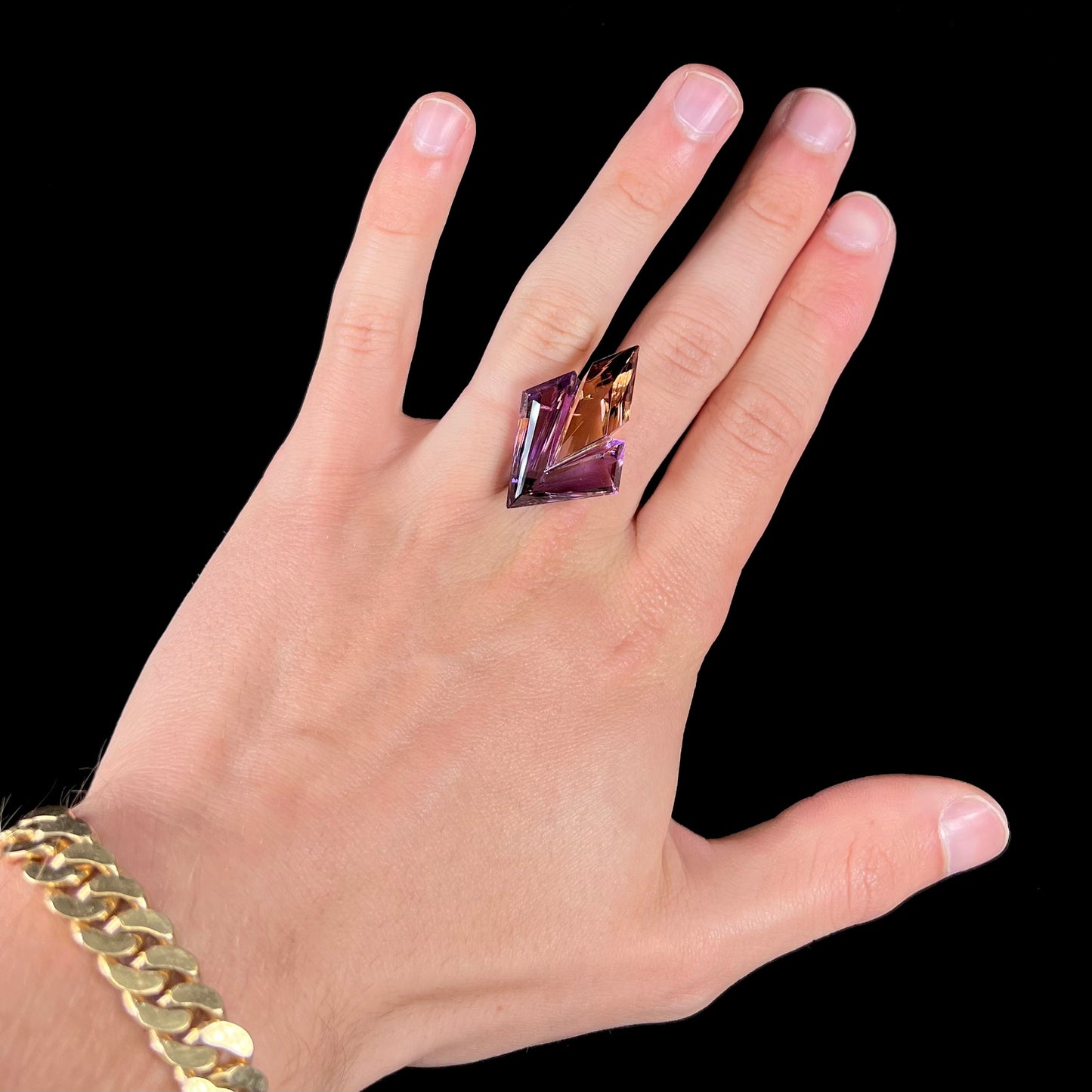 A loose, faceted fantasy cut ametrine gemstone cut by famous carver, Arthur Lee Anderson.