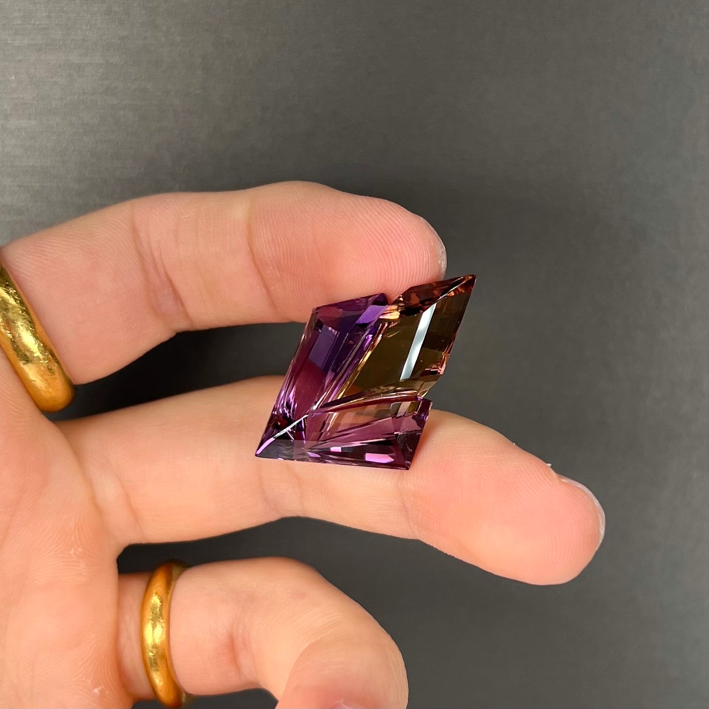 A loose, faceted fantasy cut ametrine gemstone cut by famous carver, Arthur Lee Anderson.