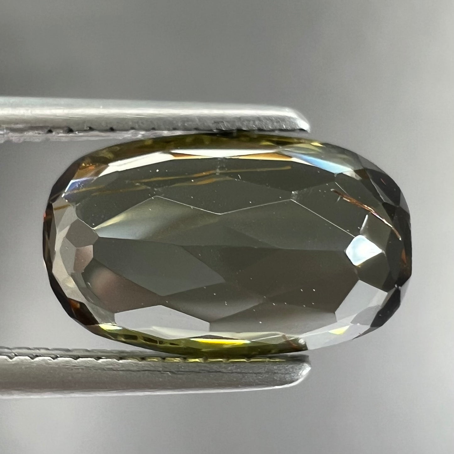 A modified oval cut andalusite gemstone. The stone has eye-visible rutile inclusions.