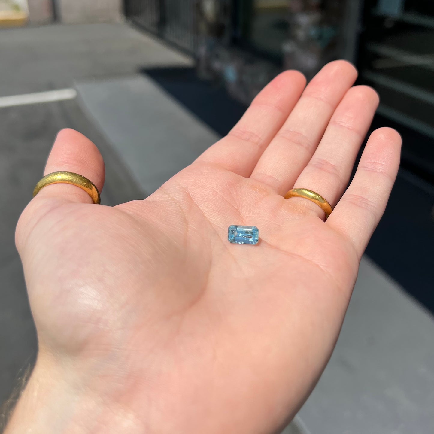 A loose, faceted emerald cut aquamarine stone. The stone is icy blue in color, indicative of Vietnamese origin.