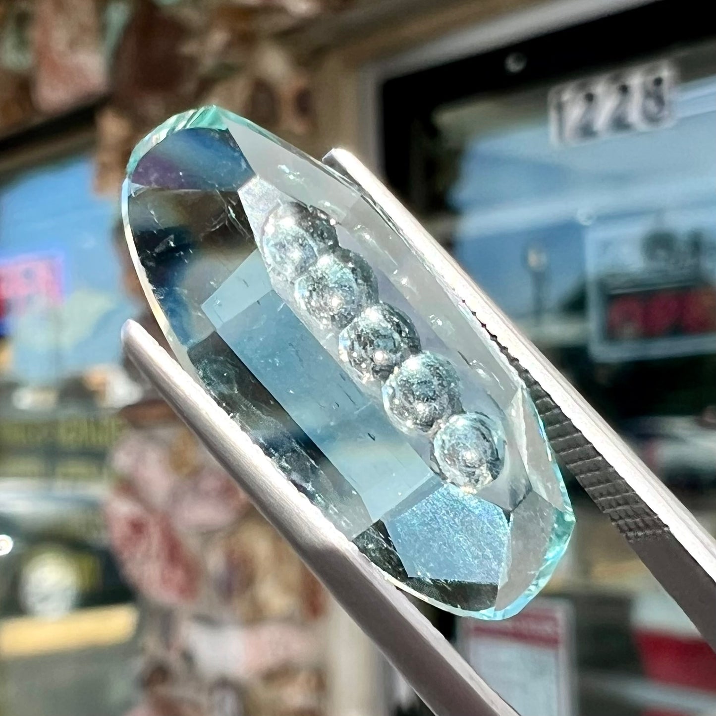An oval fantasy cut greenish blue aquamarine stone cut by gem carver, Arthur Lee Anderson.