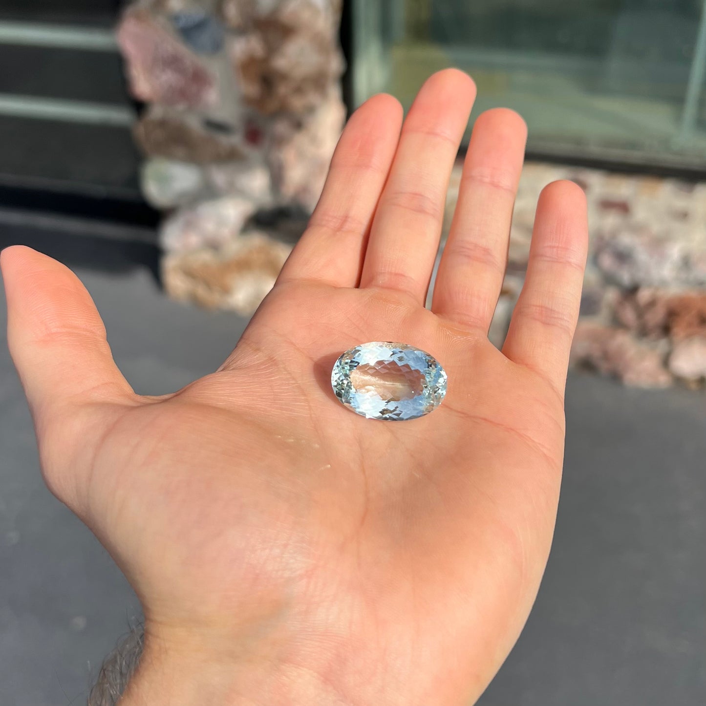 A faceted oval cut Brazilian aquamarine gemstone. The stone is a light blue color.