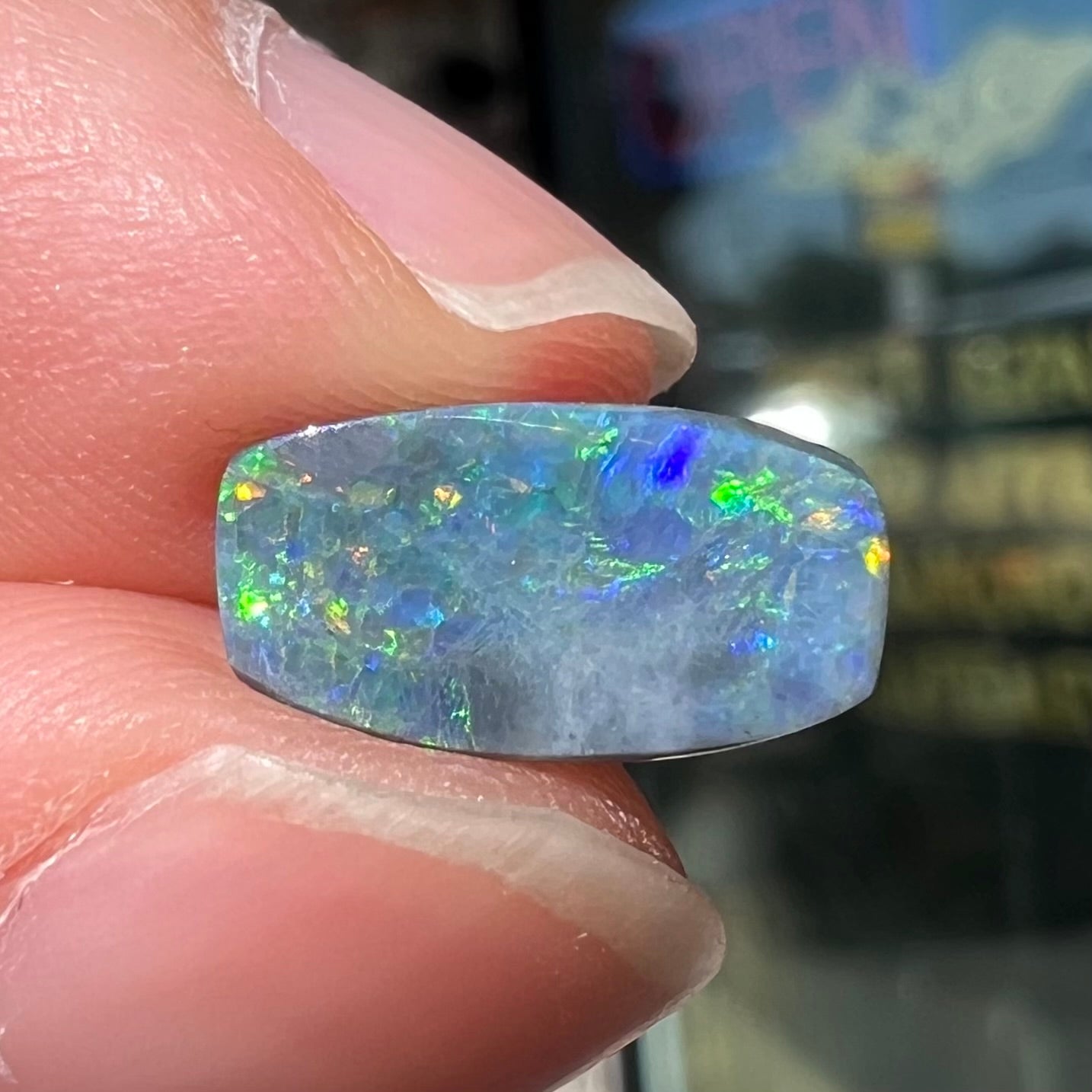 A loose 1.76ct barrel shaped black opal stone from Lightning Ridge, Australia. The opal has a rainbow of colors.