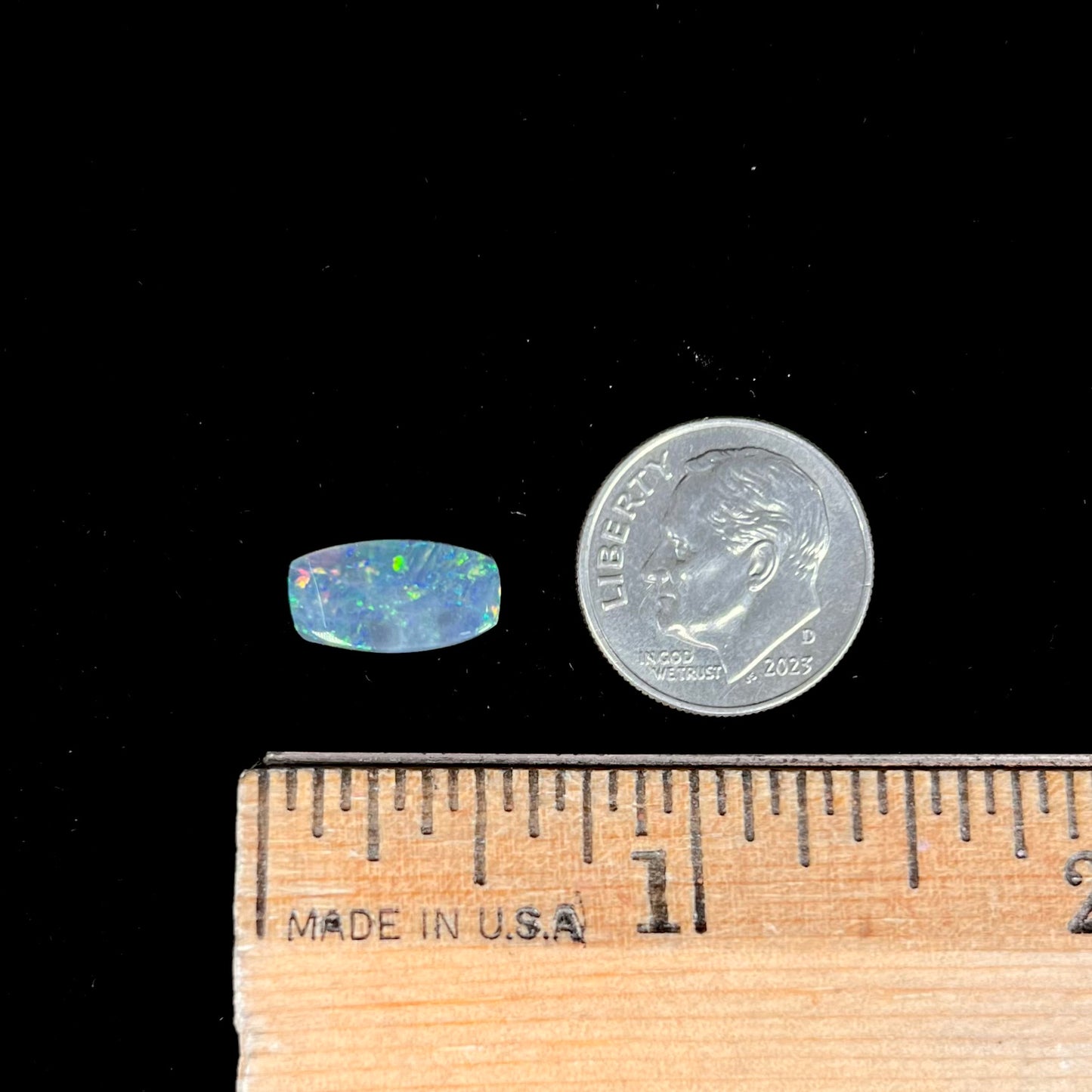 A loose 1.76ct barrel shaped black opal stone from Lightning Ridge, Australia. The opal has a rainbow of colors.