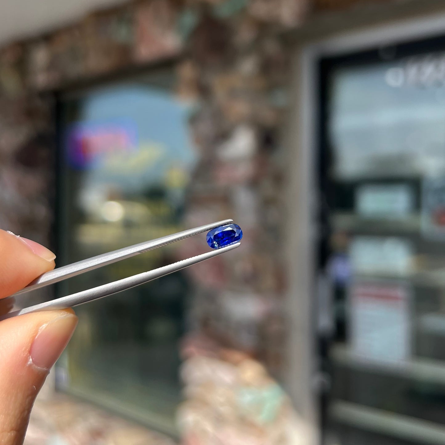 A loose, elongated oval cut blue sapphire gemstone.