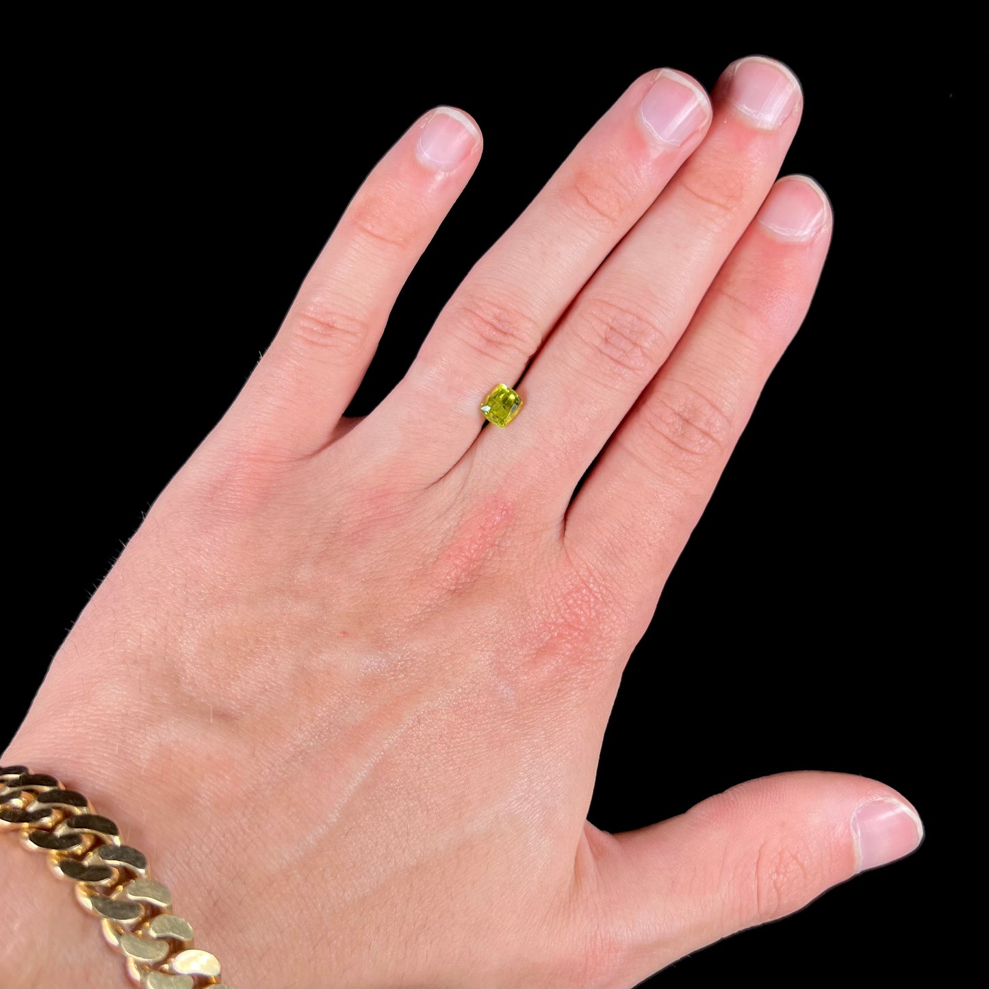 A loose, modified cushion cut greenish yellow chrysoberyl gemstone.
