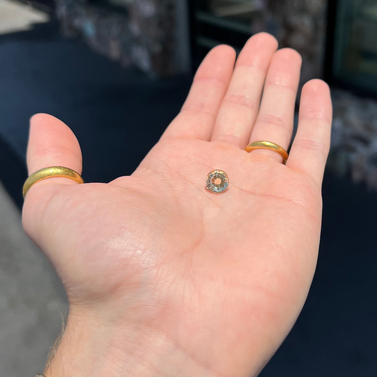 A loose, round brilliant cut citrine gemstone. The stone is light yellow color.