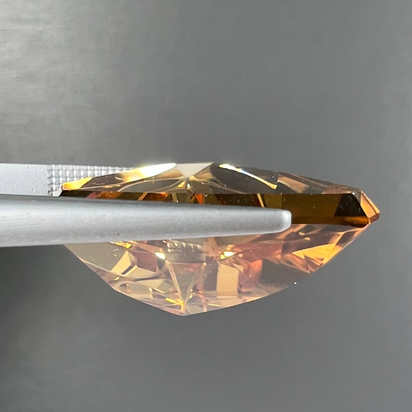A loose, triangular fantasy cut yellow citrine stone cut by Arthur Lee Anderson.
