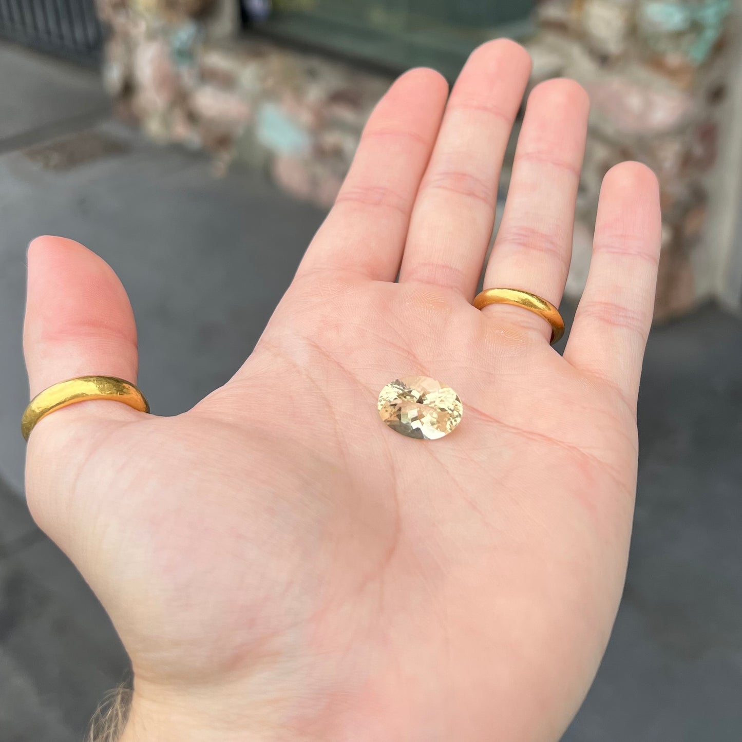 A loose, faceted oval cut citrine stone. The stone is light yellow in color.