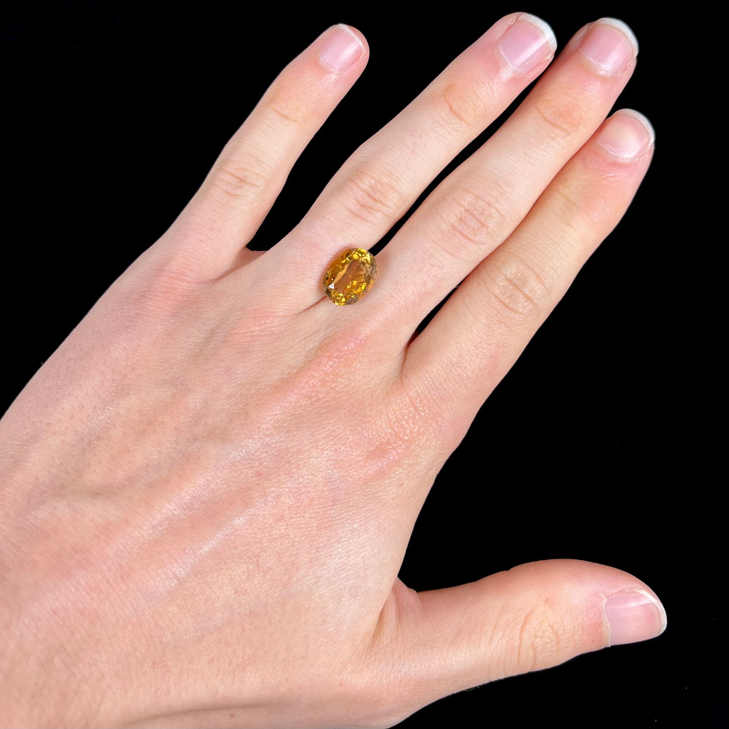 A loose, oval cut citrine gemstone. The stone is heavily included and roughly cut.