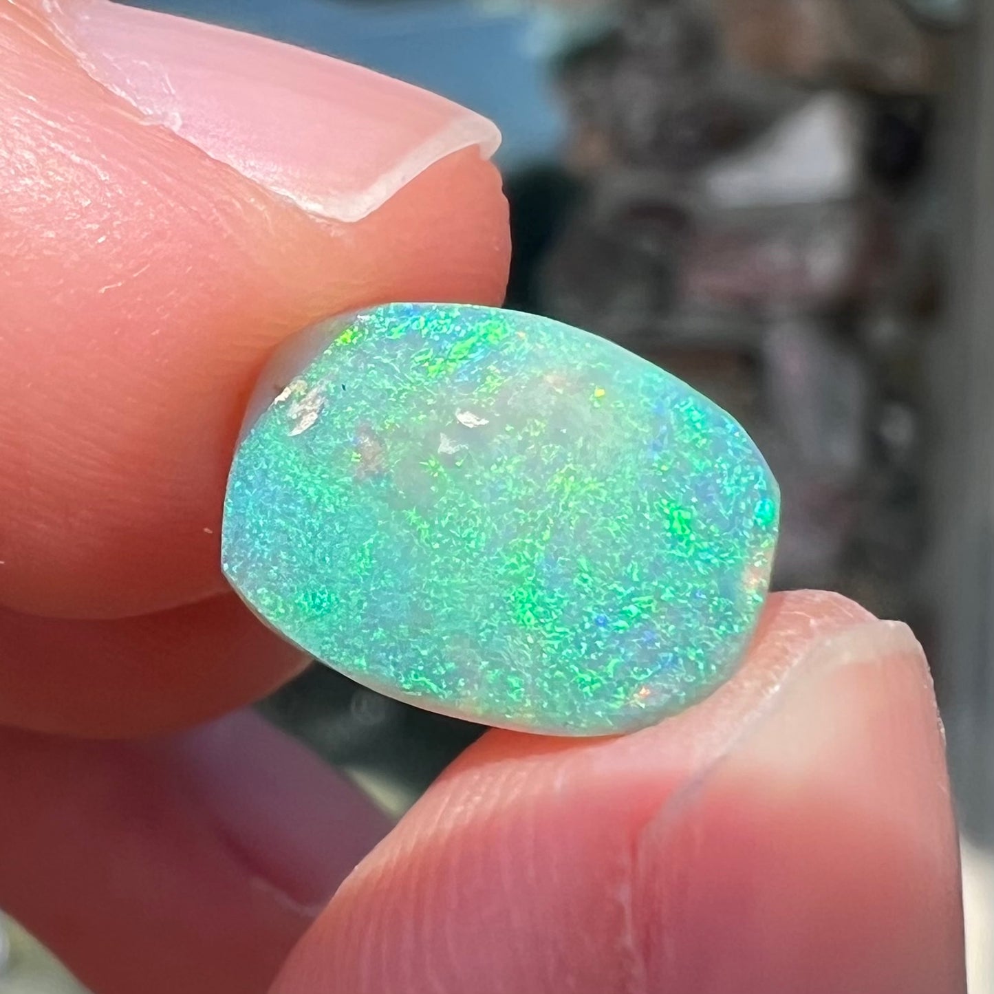 A 2.40ct barrel shaped Lightning Ridge semi-crystal opal. The stone has blue and green colors.