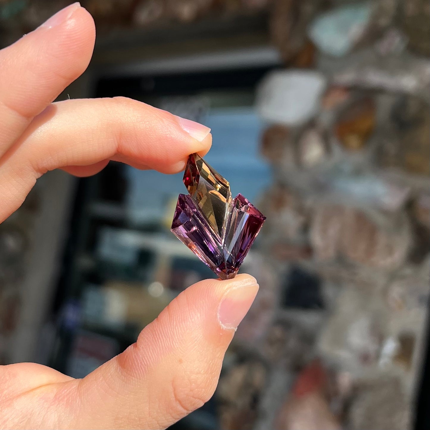 A loose, faceted fantasy cut ametrine gemstone cut by famous carver, Arthur Lee Anderson.