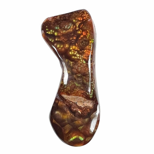A loose, freeform cabochon cut fire agate gemstone.  The stone exhibits a bubbly pattern.