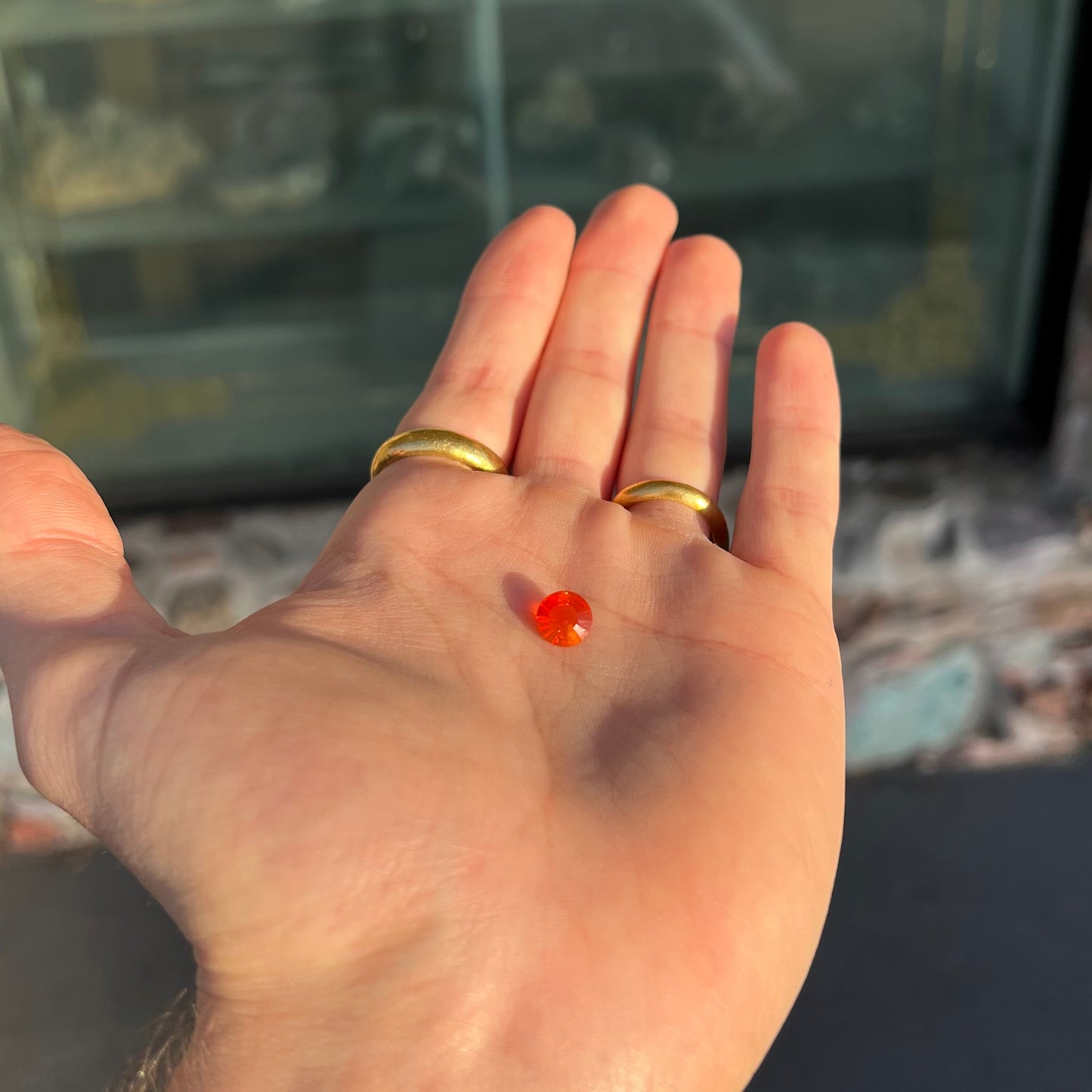 A faceted round cut natural fire opal from Mexico. The stone is a bright orange color.