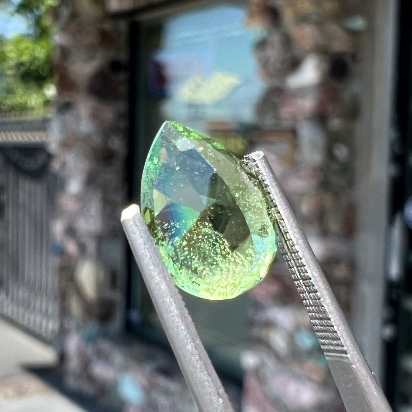 A loose, pear shaped tsavorite garnet gemstone. The stone is yellowish green.