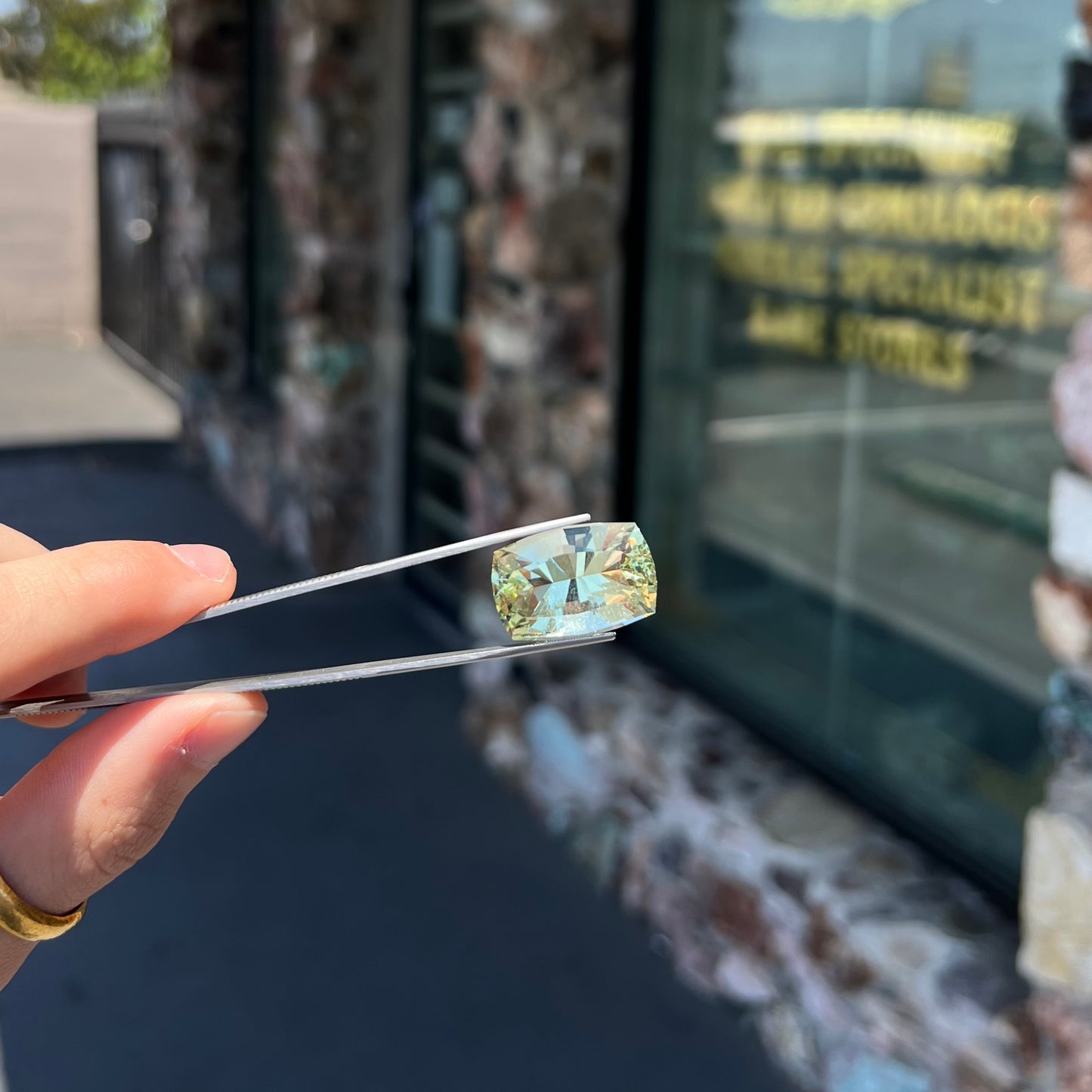 A loose, modified cushion cut heliodor beryl gemstone. The stone is a yellow-green color.