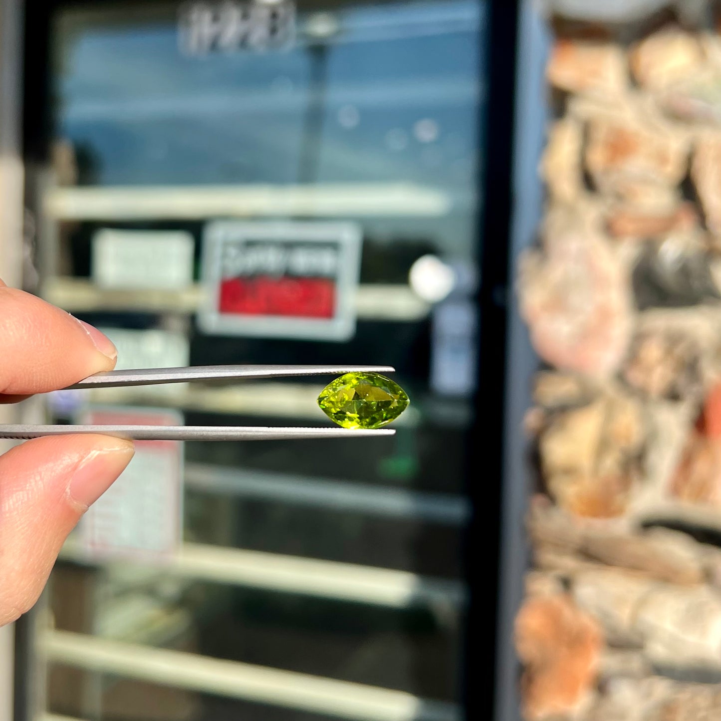 A loose, marquise cut peridot gemstone. The stone is an olive green color.
