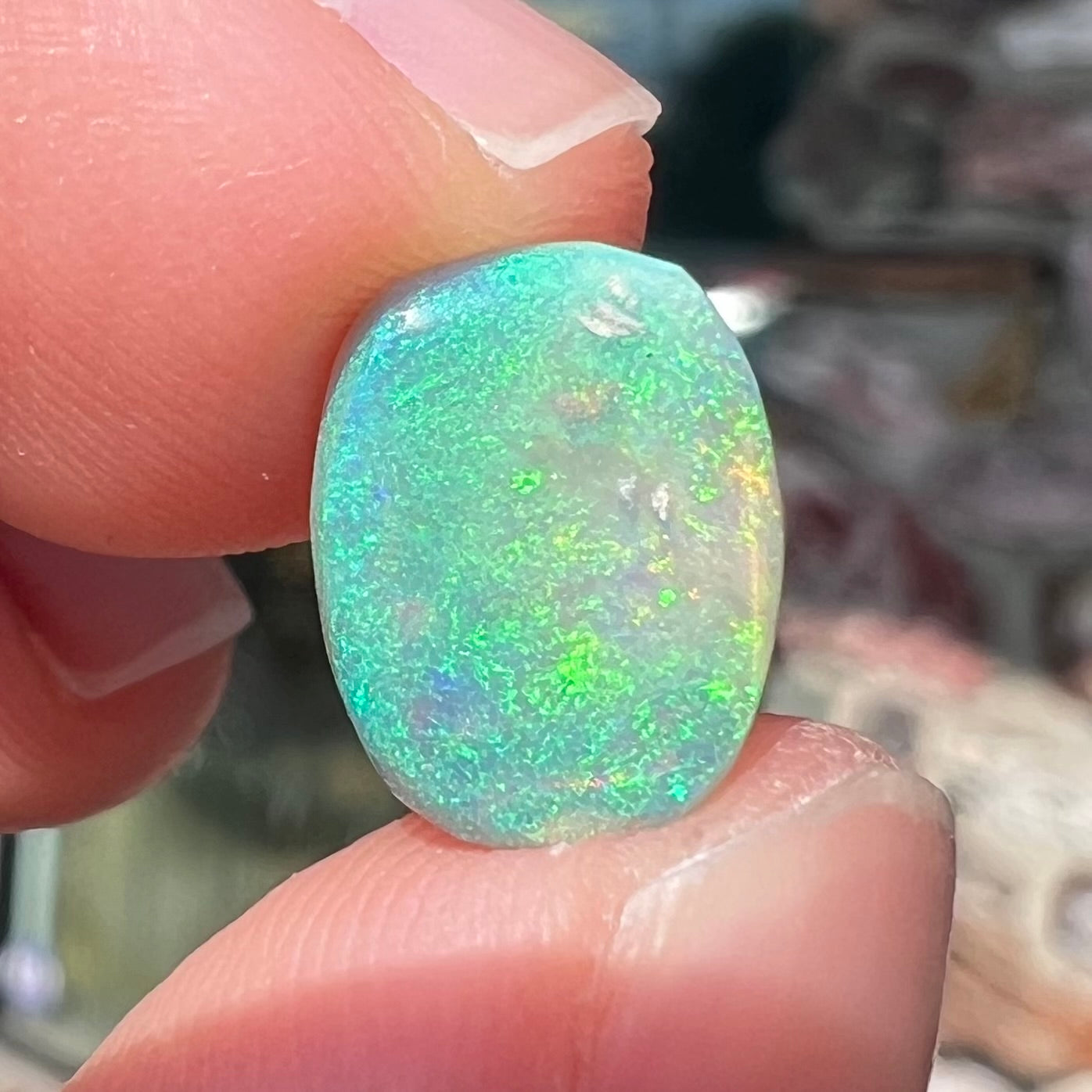 A 2.40ct barrel shaped Lightning Ridge semi-crystal opal. The stone has blue and green colors.