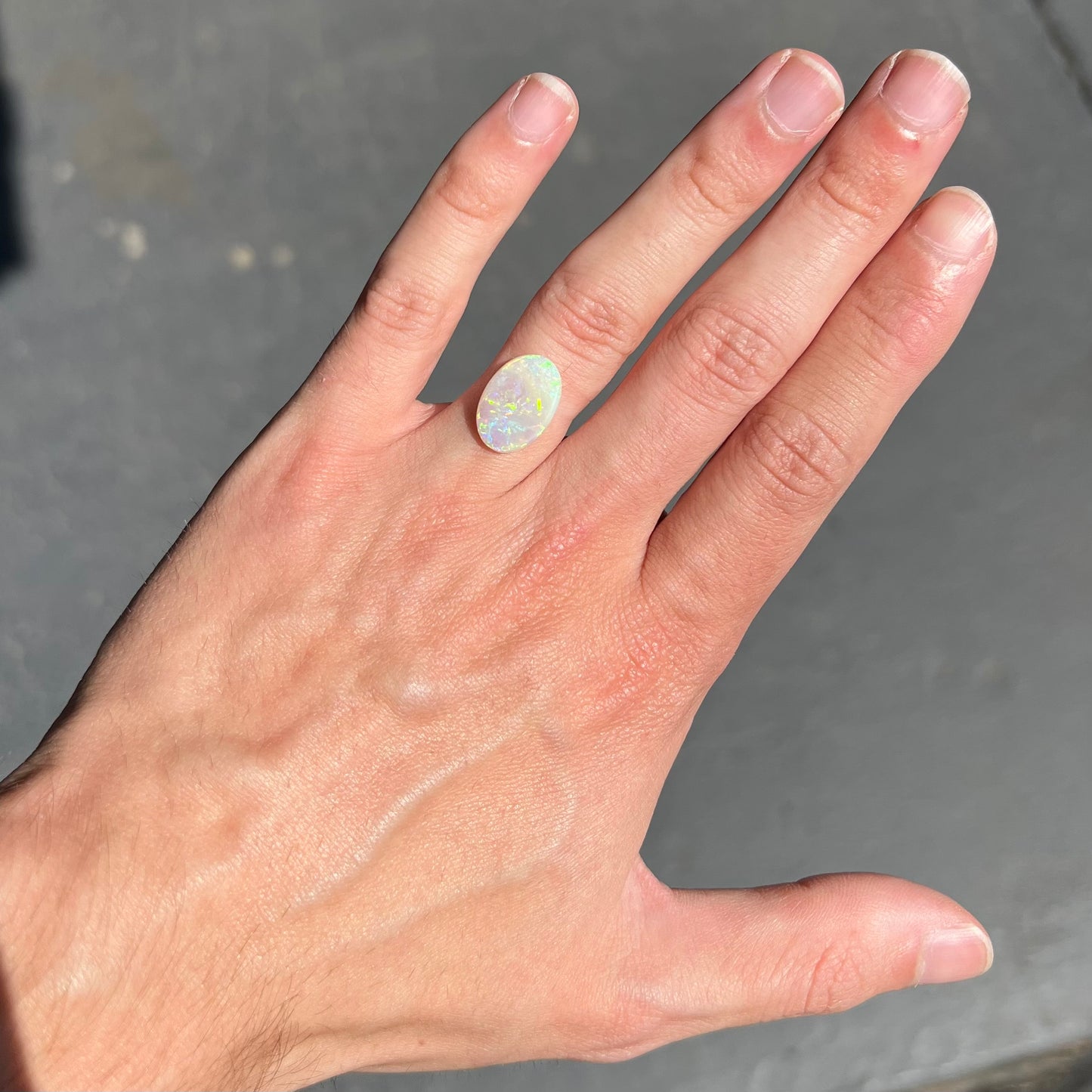 A double-sided opal stone from Coober Pedy, Australia. The opal plays green, blue, and orange colors from the front and the back.