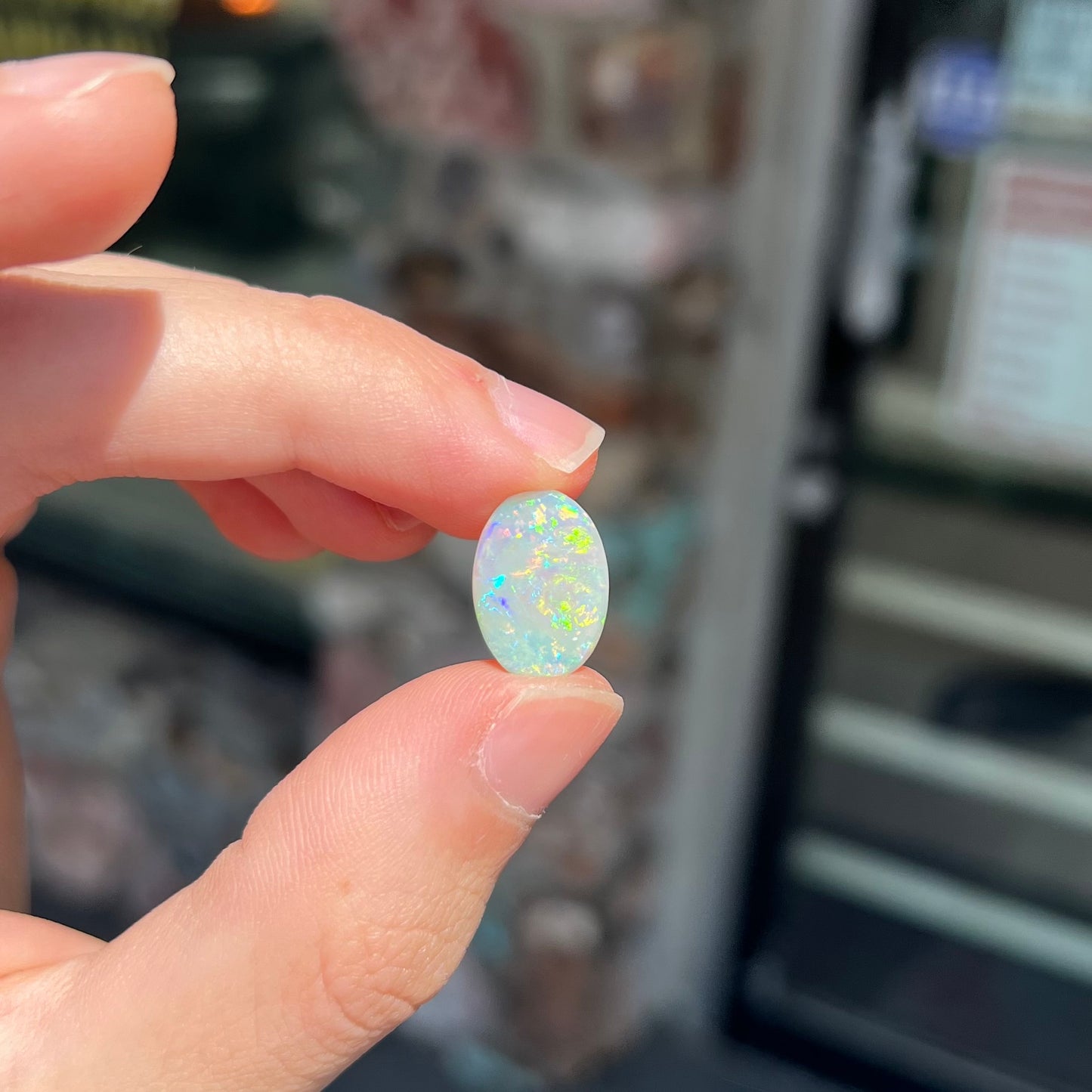 A double-sided opal stone from Coober Pedy, Australia. The opal plays green, blue, and orange colors from the front and the back.