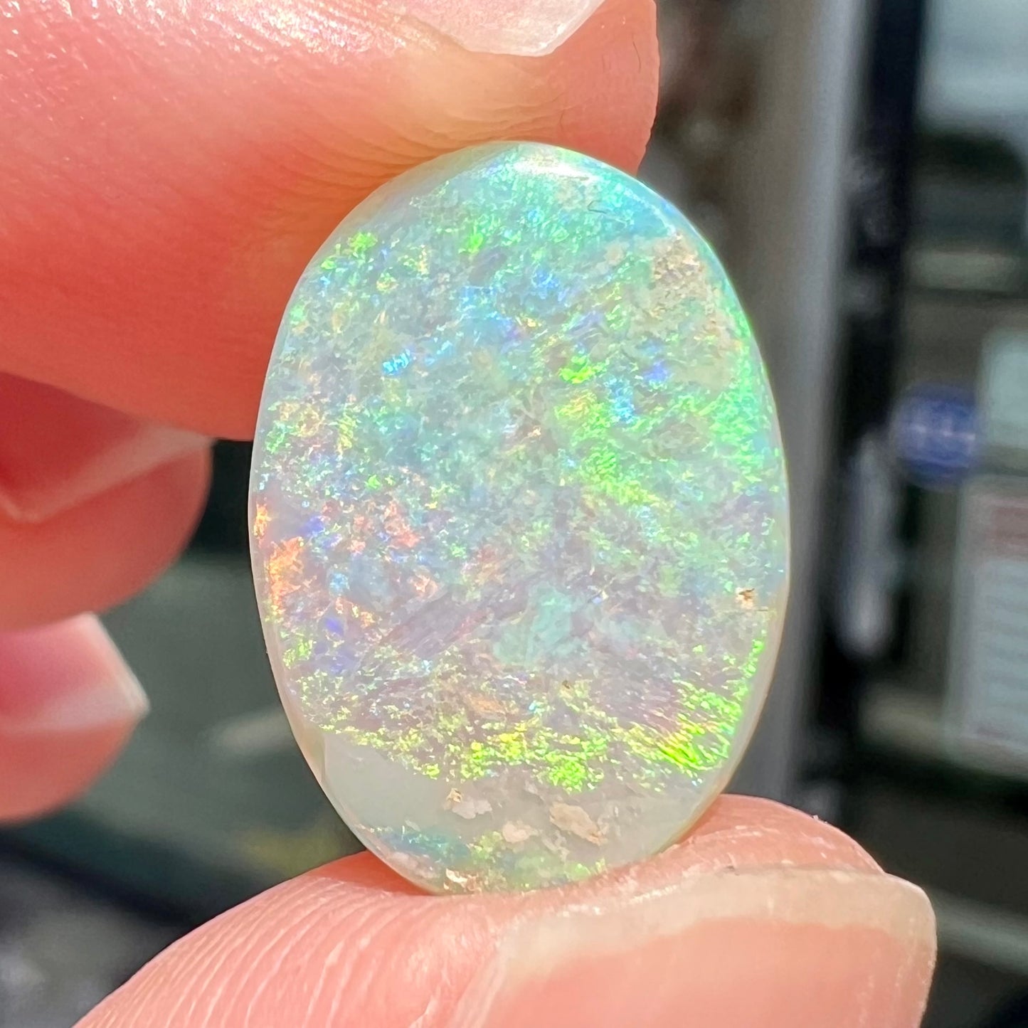 A double-sided opal stone from Coober Pedy, Australia. The opal plays green, blue, and orange colors from the front and the back.